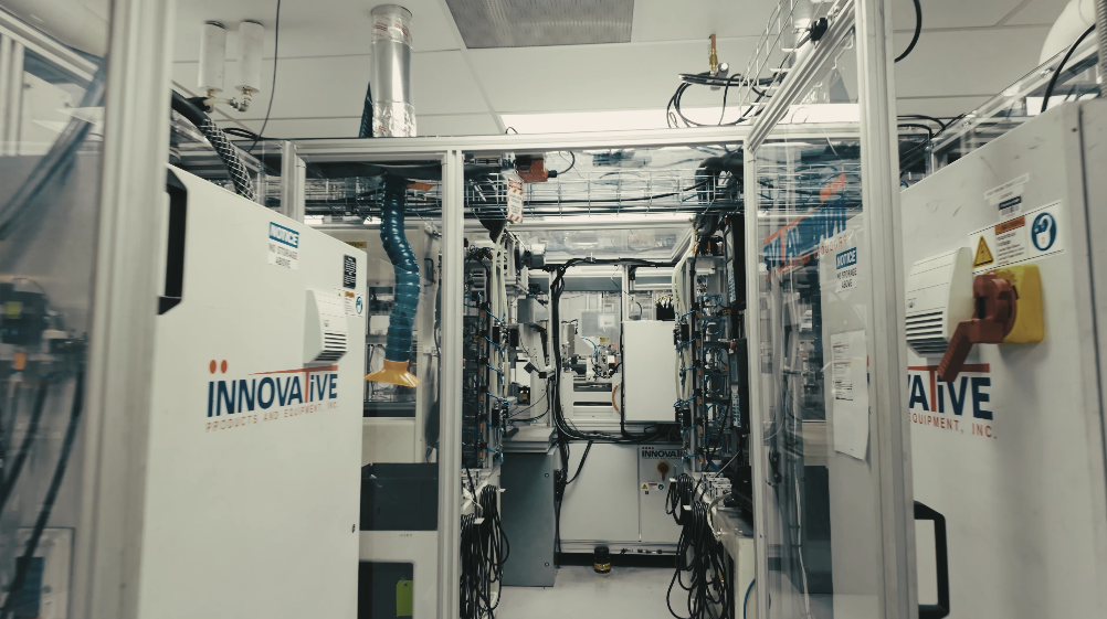 Industrial laboratory or manufacturing facility with equipment and machinery labeled 'Innovative' and controlled access.