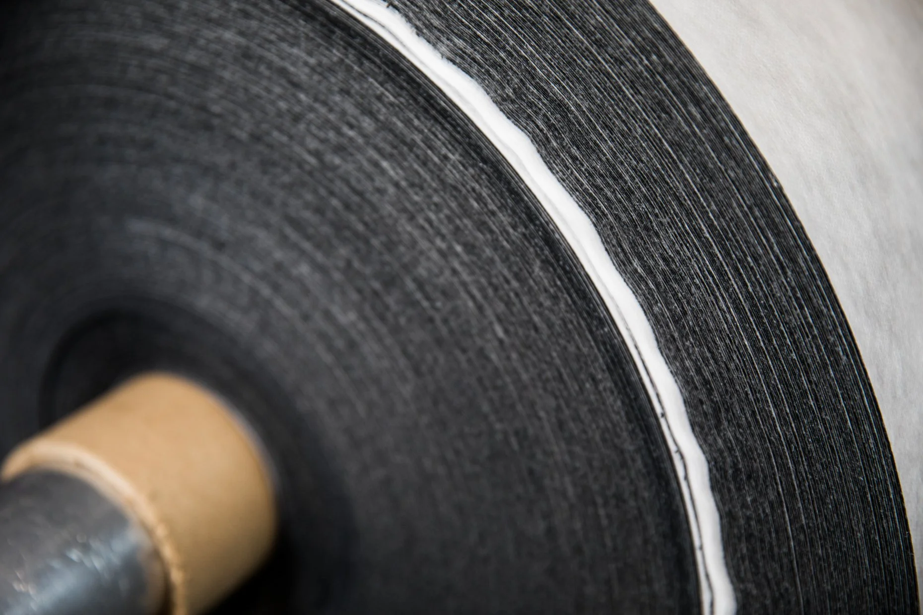 Close-up of a vinyl record on a turntable, showing the textured surface and curved edge of the record.