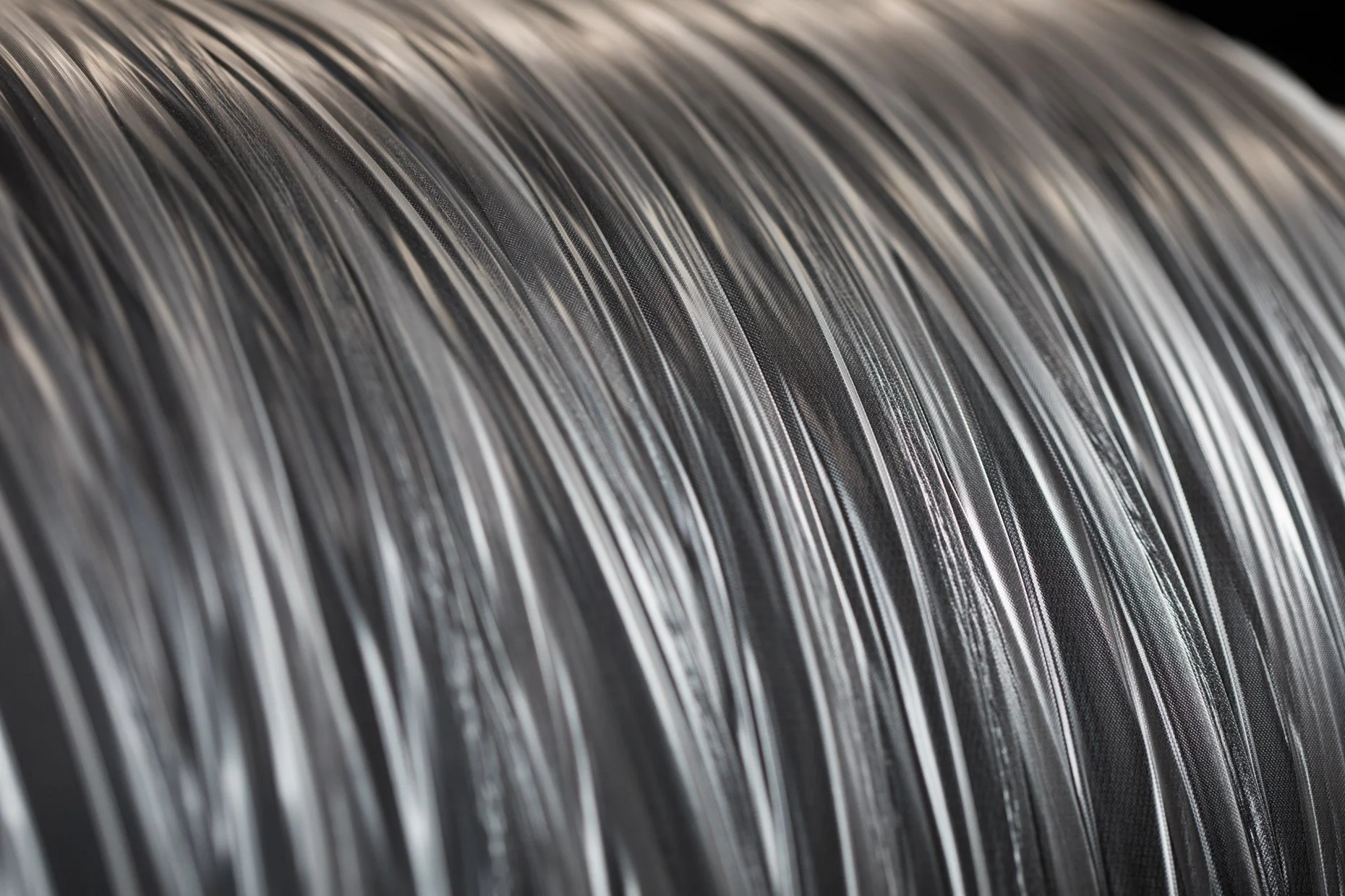 Close-up of a vinyl record's grooves, showing the circular ridges and reflections.
