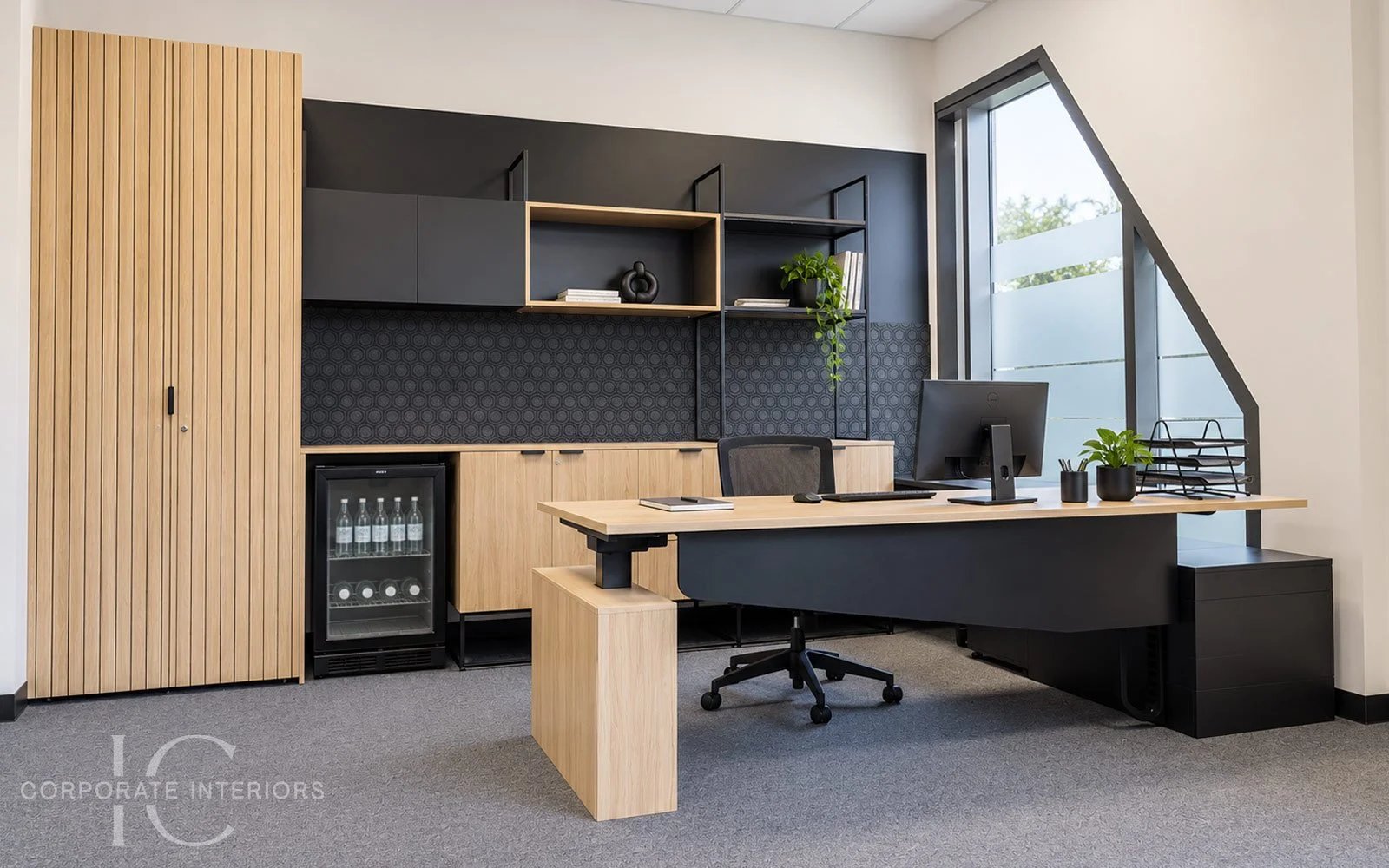 Principal office with height adjustable executive desk, custom cabinetry, feature shelving and integrated storage.