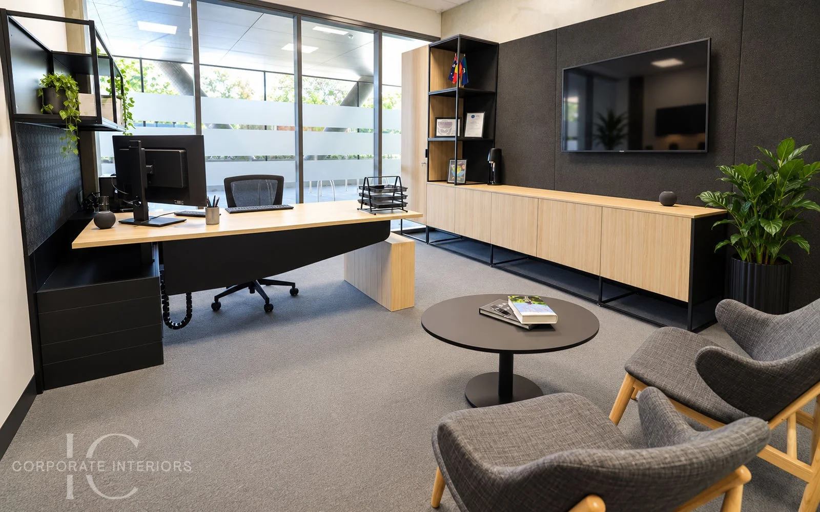 Executive office with timber height adjustable desk, custom storage and informal meeting area.
