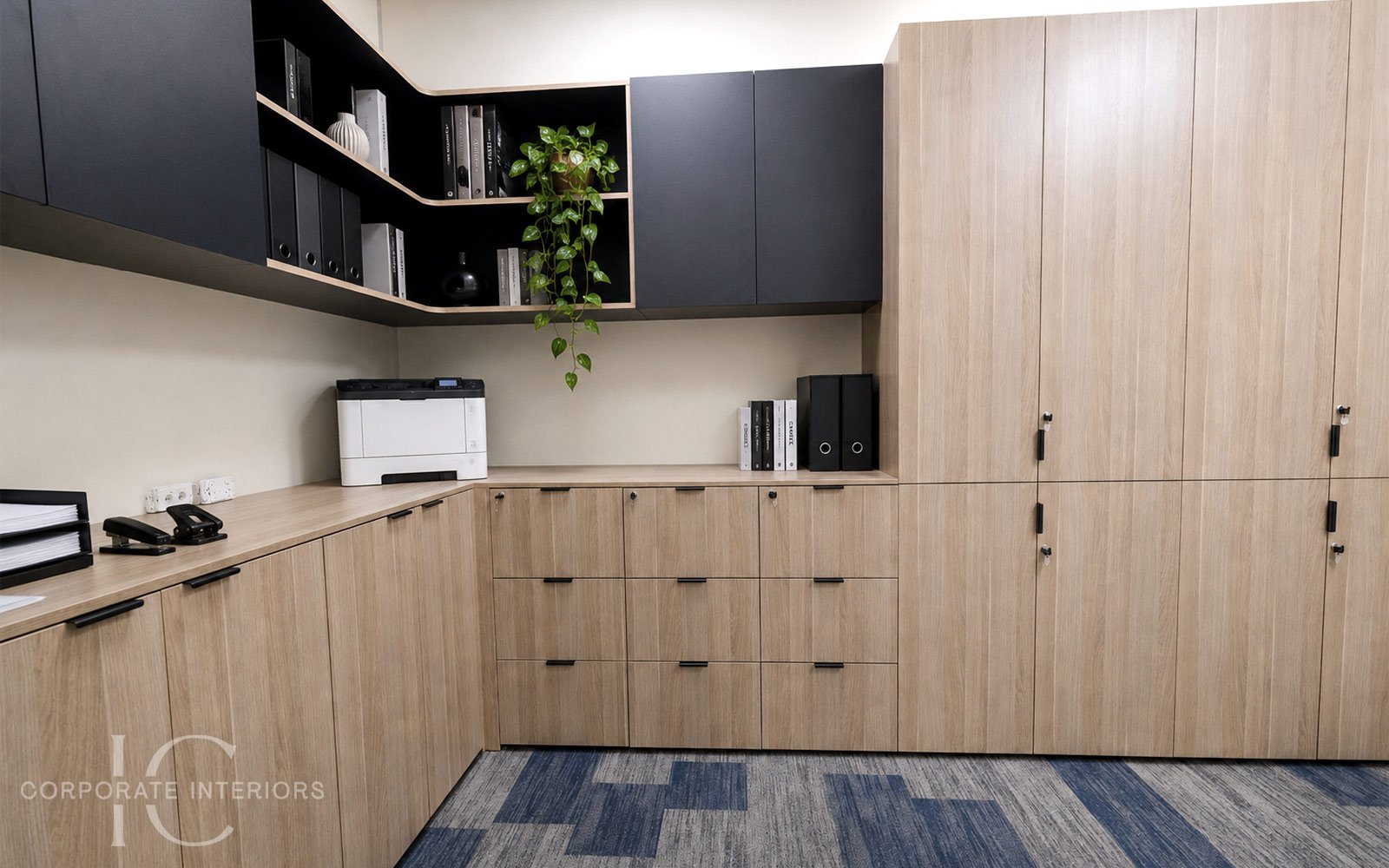 Integrated printer bench and additional low-level storage provide a practical printer and utilities area with easy access to files, equipment and office supplies.