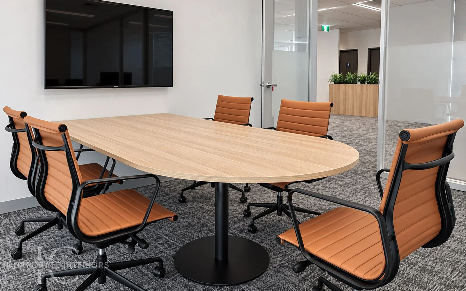 D-end timber boardroom table with black pedestal base and tan leather boardroom chairs in a glazed meeting room.