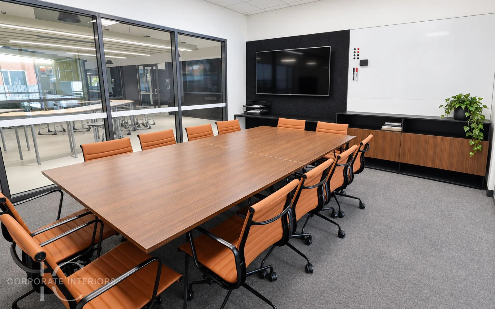 Timber conference table with boardroom chairs, custom storage with black metal features.