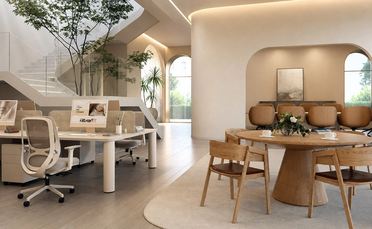 Modern office space with round wooden meeting table, chairs, beige walls, large windows, and decorative plants.