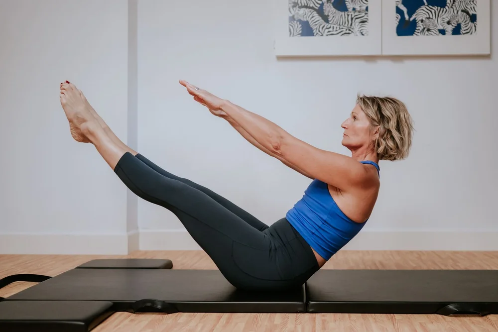Laura Martin performing a Pilates teaser on the mat