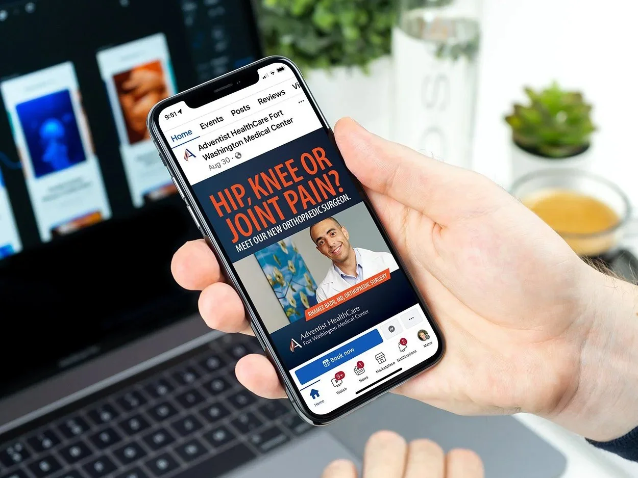 Person holding a smartphone displaying the Facebook page for Adventist HealthCare Fort Washington Medical Center, featuring an advertisement for orthopedic surgery for hip, knee, or joint pain with an image of a male doctor.