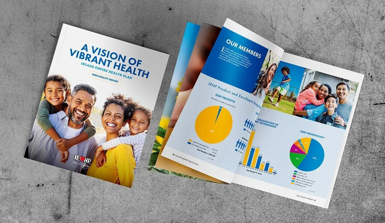 Brochure and open report on a gray surface. The brochure title reads 'A Vision of Vibrant Health' with a photo of a smiling family. The open report displays pie charts, bar graphs, and photos related to health plan statistics.