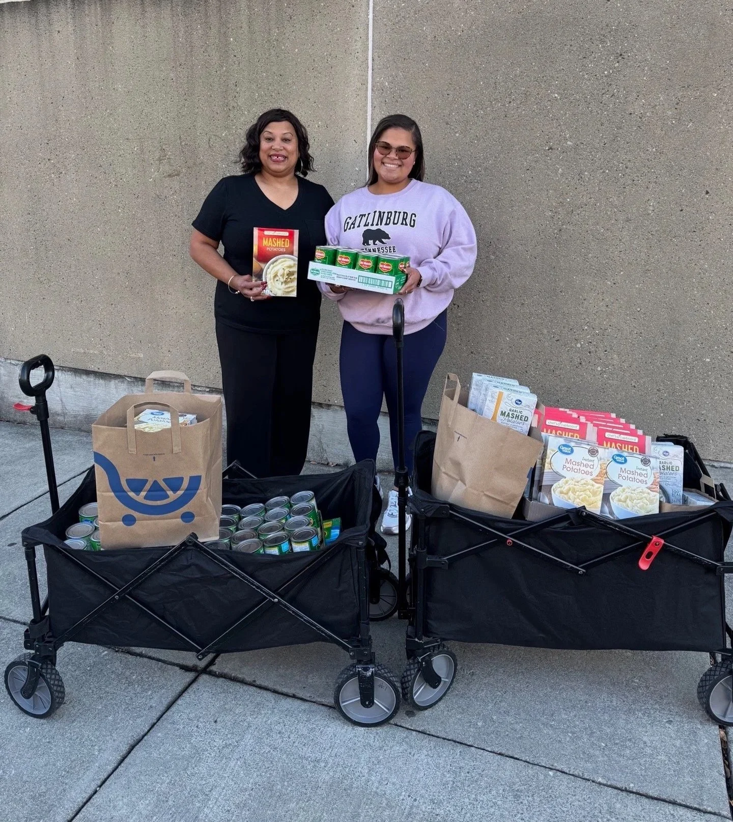 two woman standing in front of wagons filled with food