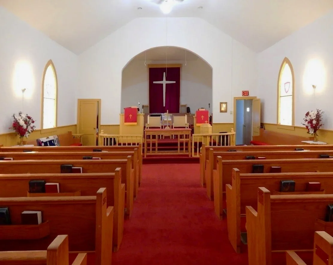 A photo of a church sanctuary looking toward the alter.