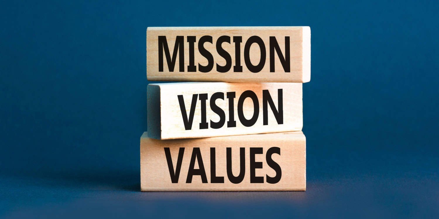 Wooden blocks stacked with the words 'MISSION,' 'VISION,' and 'VALUES' on each block.