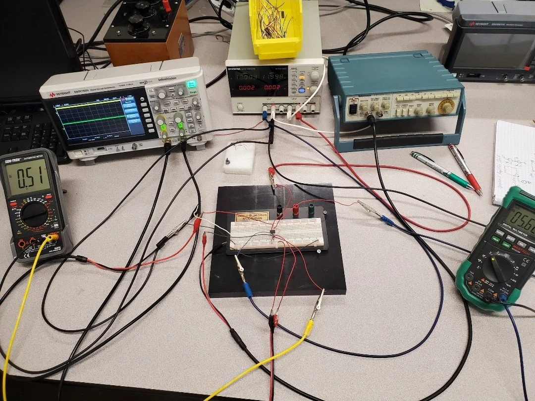 Electronic component test setup using an oscilloscope, waveform generator, power supply, wiring, and two digital multimeters