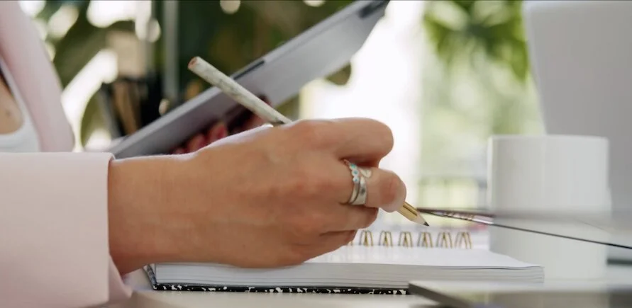 businesswoman-sketches-ideas-on-notepad-in-modern-office-setting.jpg