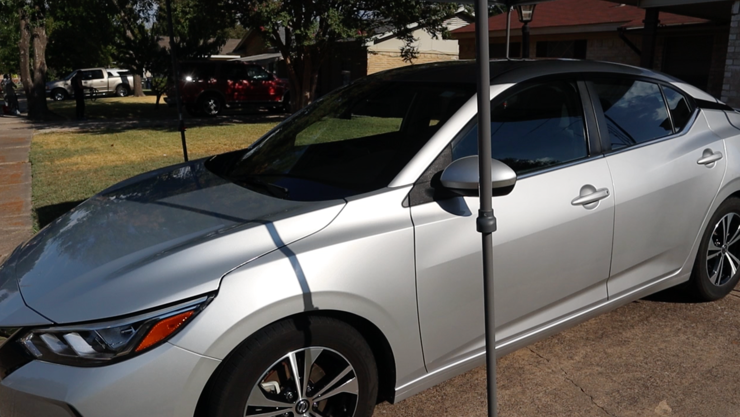 Professional mobile detailing on a white sedan in a driveway in Dallas, TX.