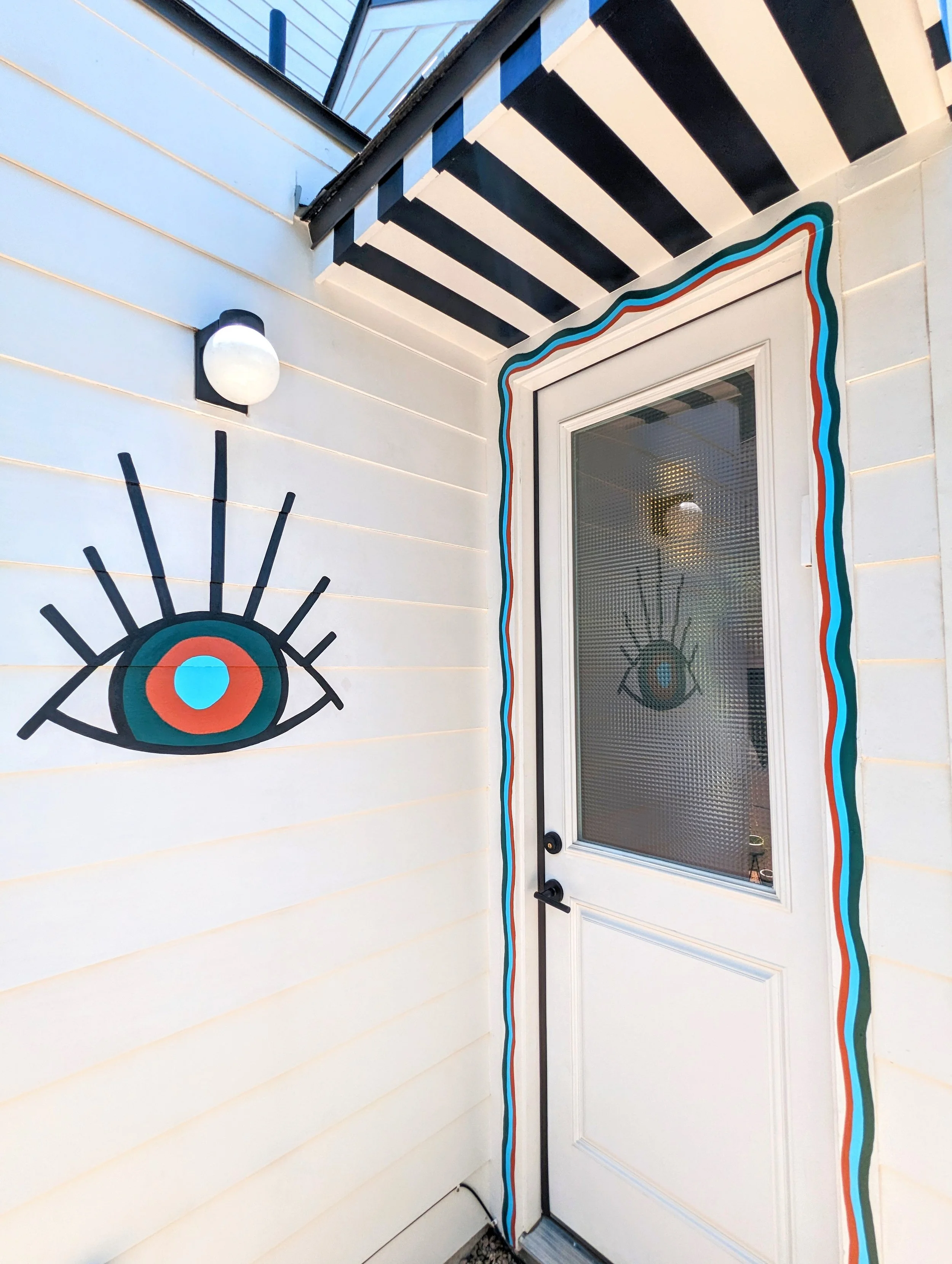 East Austin backyard fence mural inspired by El Rey Court in Santa Fe, featuring colorful geometric shapes and desert-inspired artwork.