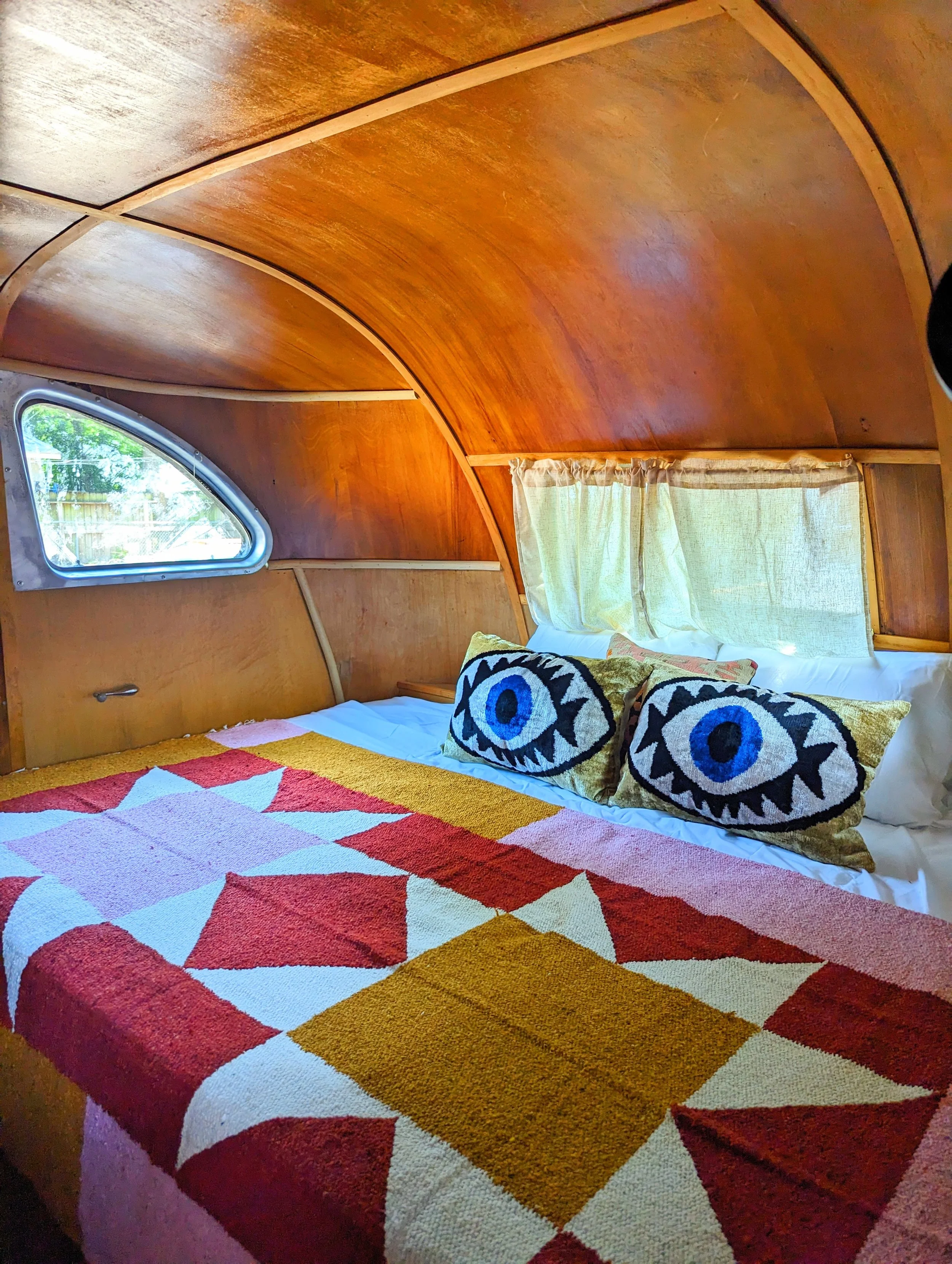 Vintage Spartan trailer interior at an Austin Airbnb inspired by El Cosmico in Marfa, featuring eclectic vintage furnishings and collected decor.