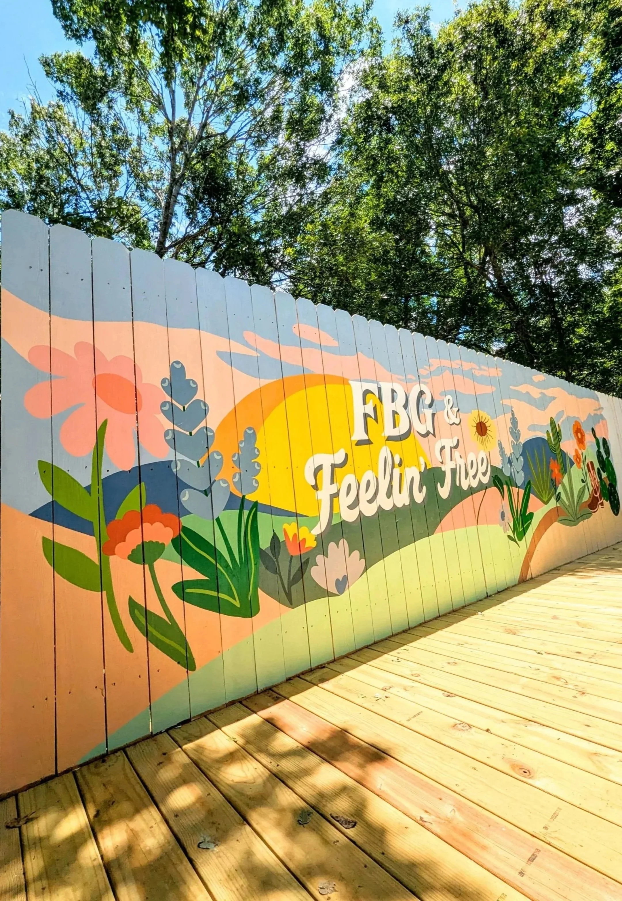 Texas Hill Country mural painted on the exterior fence of a Fredericksburg short-term rental.