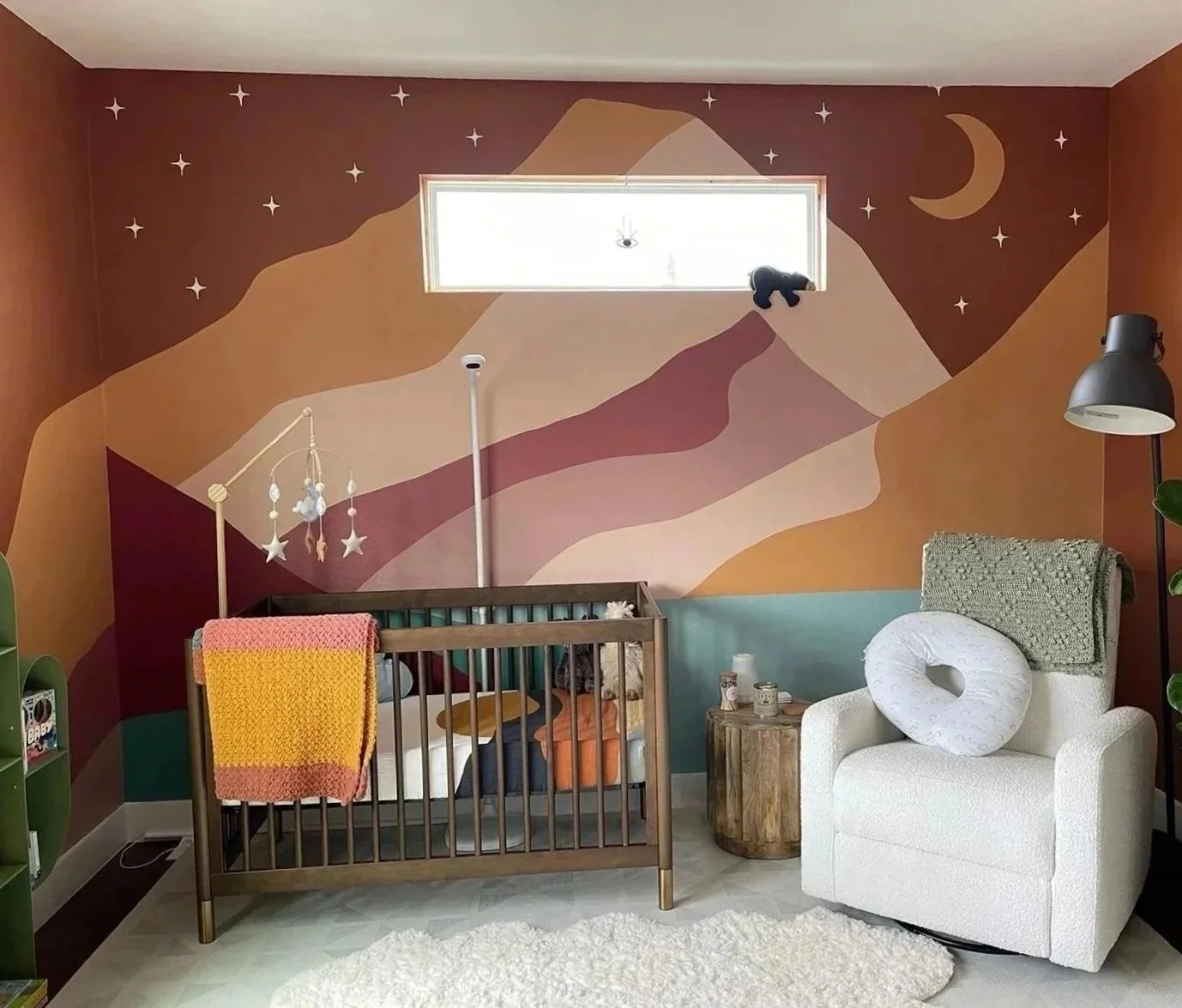 Mountain landscape nursery mural in Austin featuring layered mountains, earthy colors, stars, and a crescent moon.