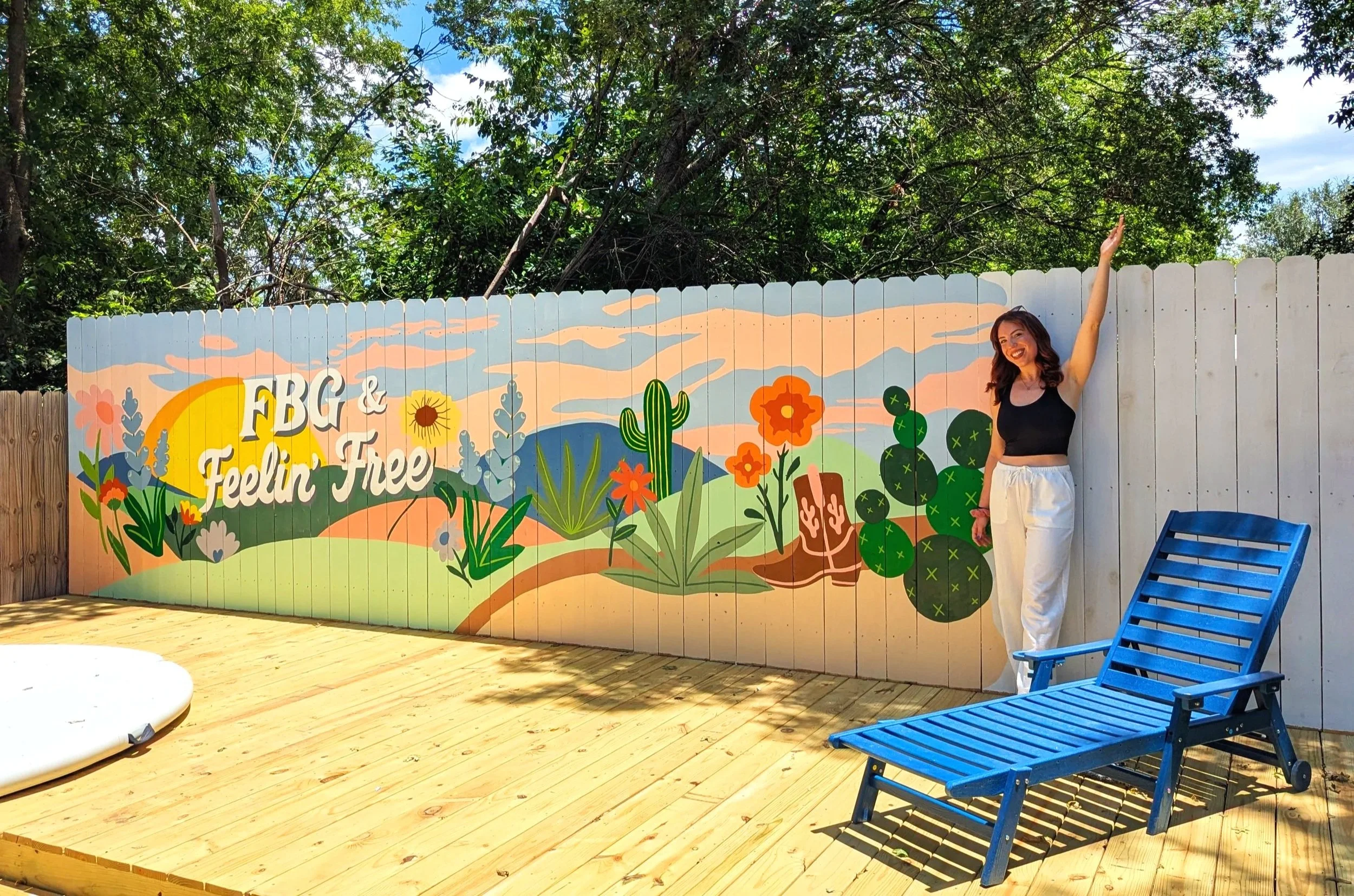 Texas Hill Country mural painted on the exterior fence of a Fredericksburg short-term rental.