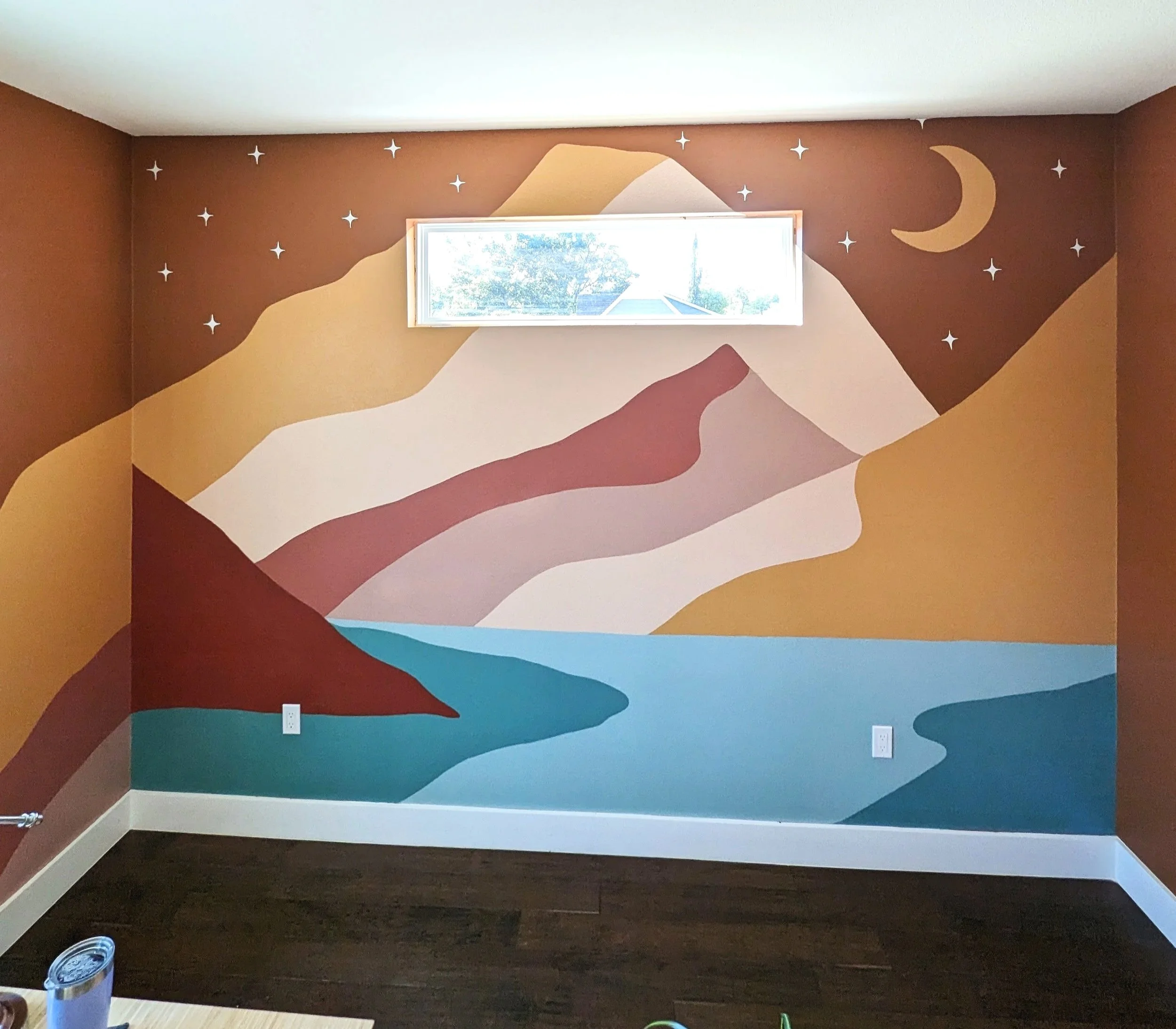 Mountain landscape nursery mural in Austin, Texas featuring earthy tones, layered mountain forms, stars, and a crescent moon.