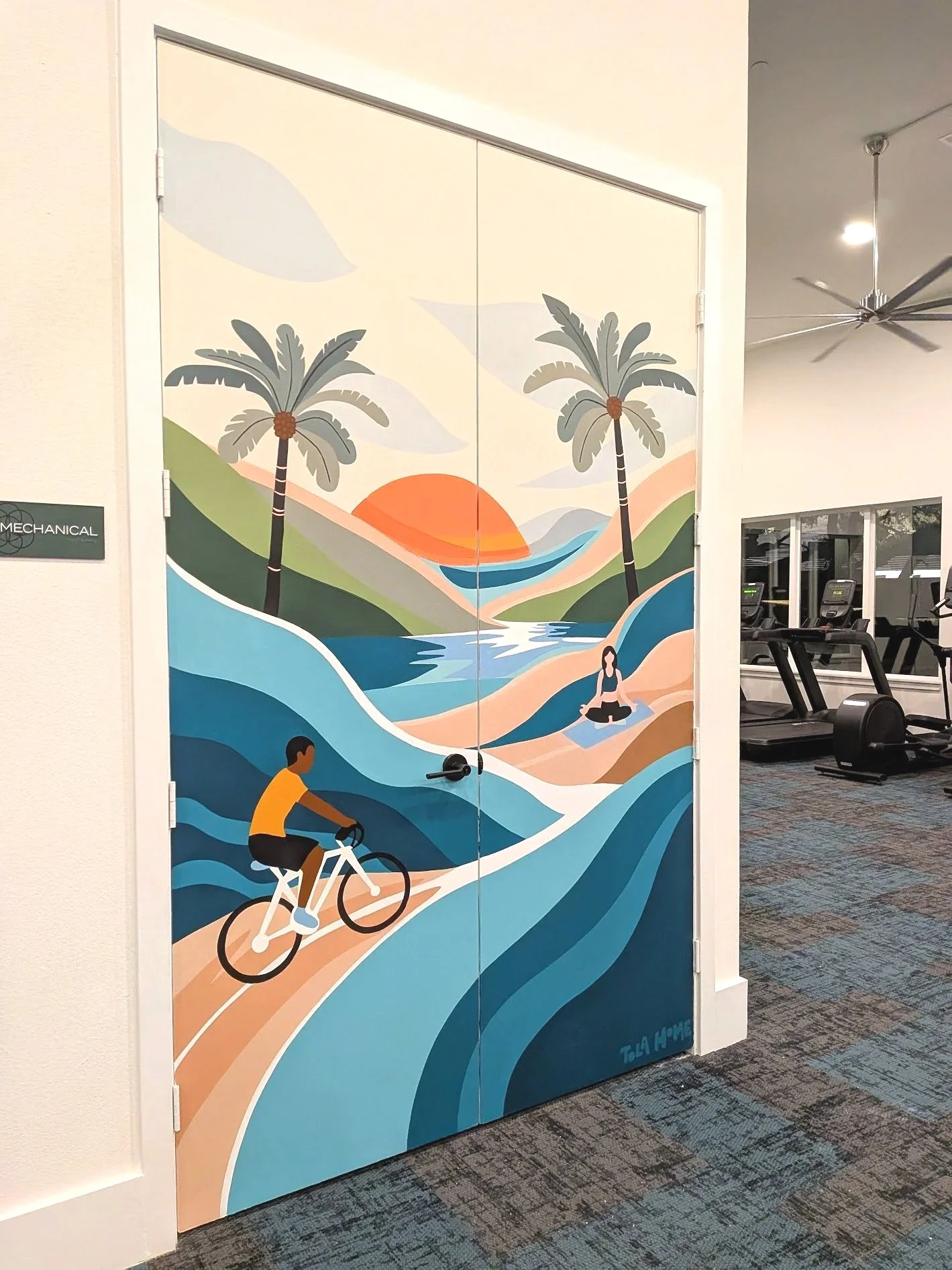 San Antonio apartment community fitness center mural featuring a tropical landscape, palm trees, cyclist, and colorful abstract waves.