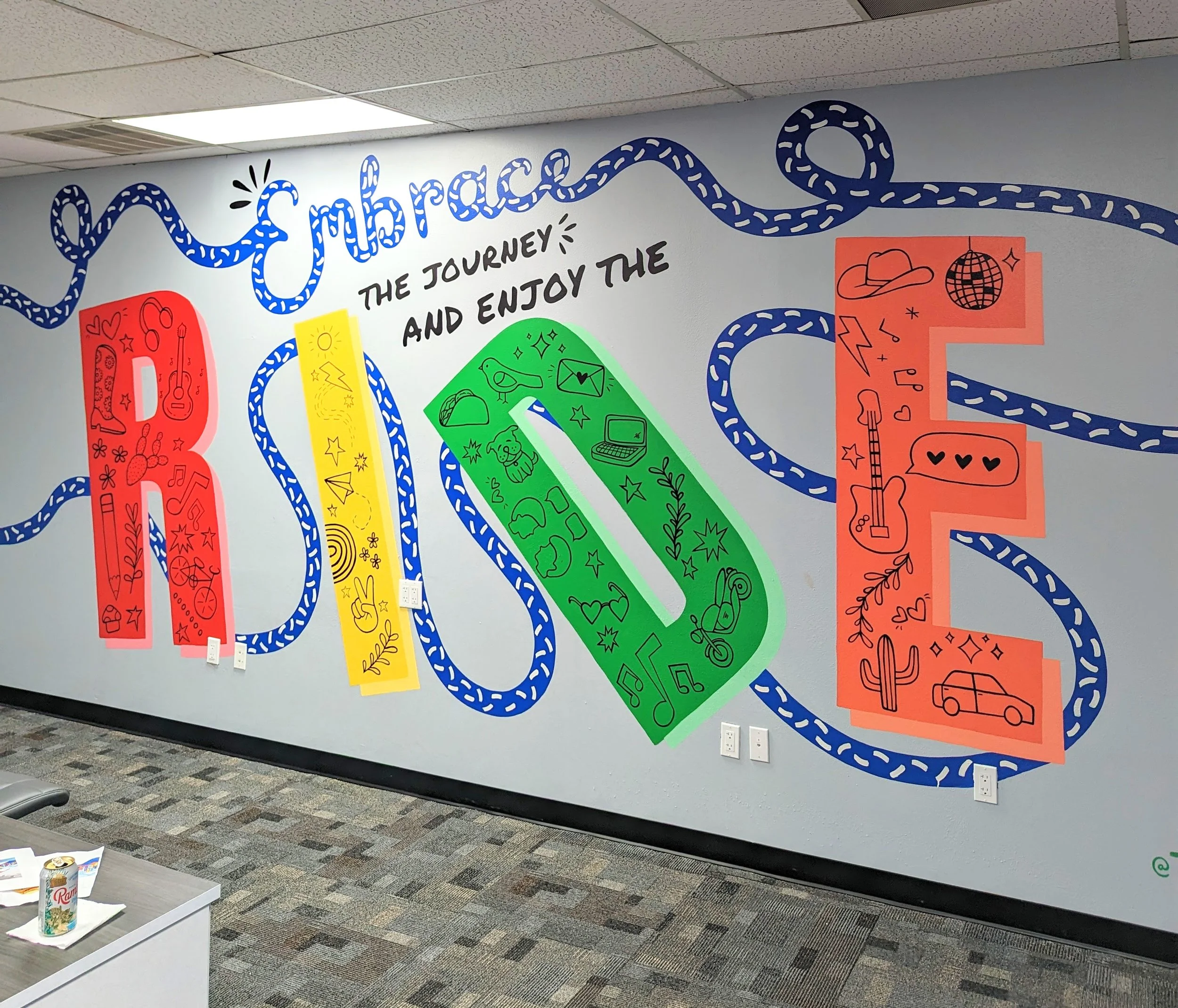 Centex Auto Title office mural in Austin featuring hand-painted typography, the phrase “Celebrate the journey and enjoy the ride,” and colorful graphic symbols.