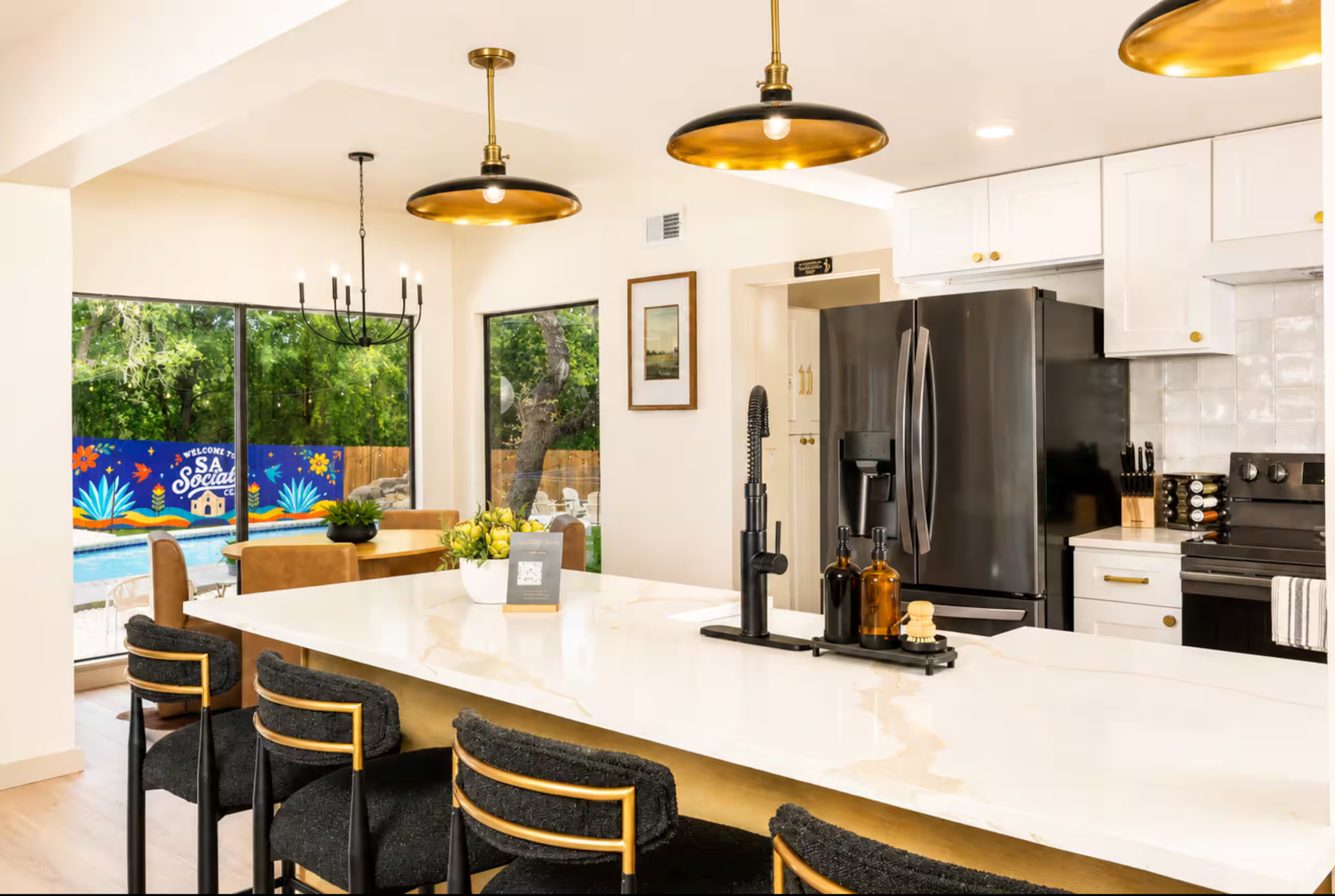 San Antonio short-term rental kitchen overlooking the backyard and colorful exterior fence mural painted for the SA Social Club airbnb property.