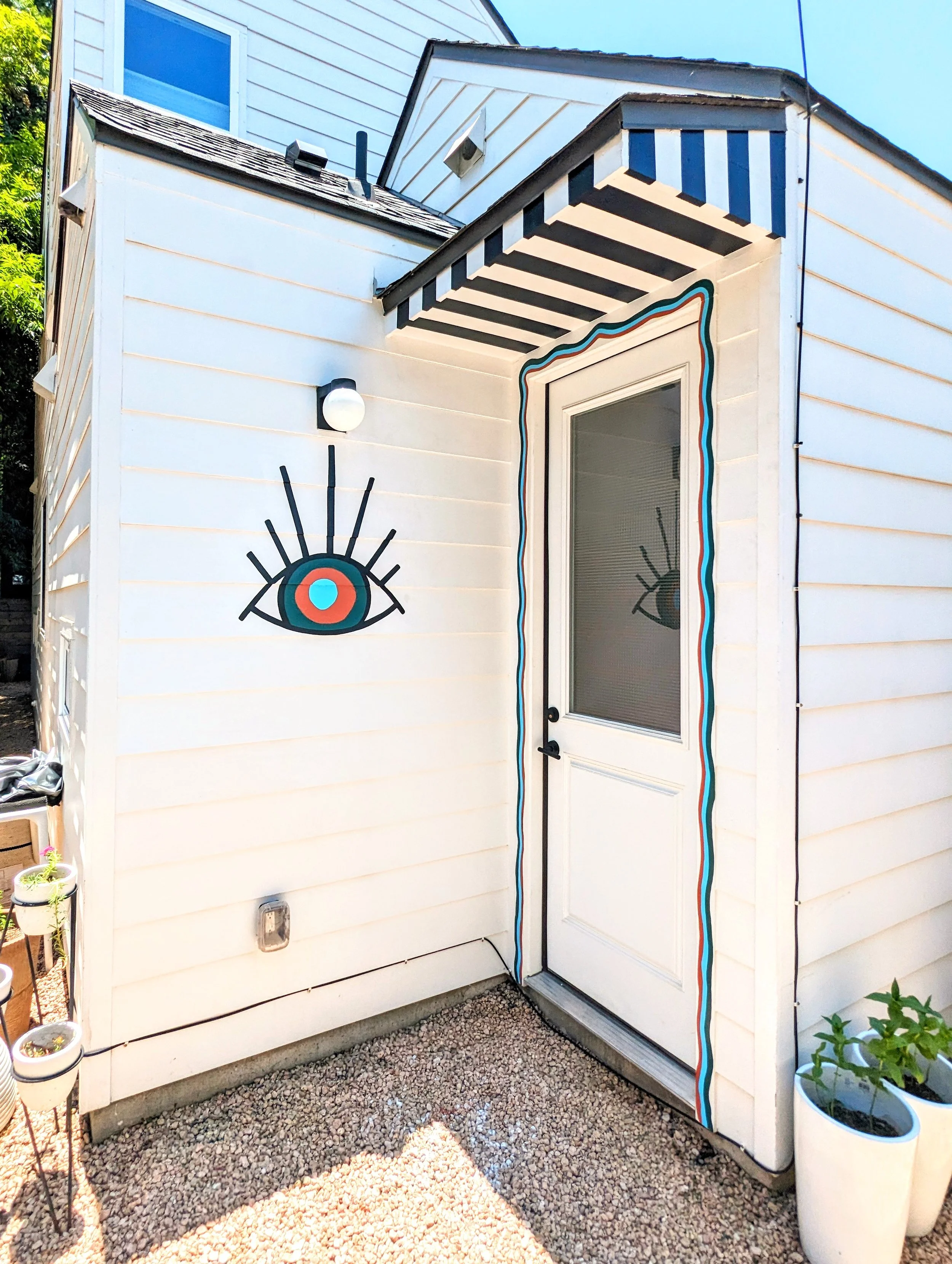 East Austin backyard mural featuring bold geometric shapes, desert plants, and a colorful painted fence inspired by Santa Fe design.