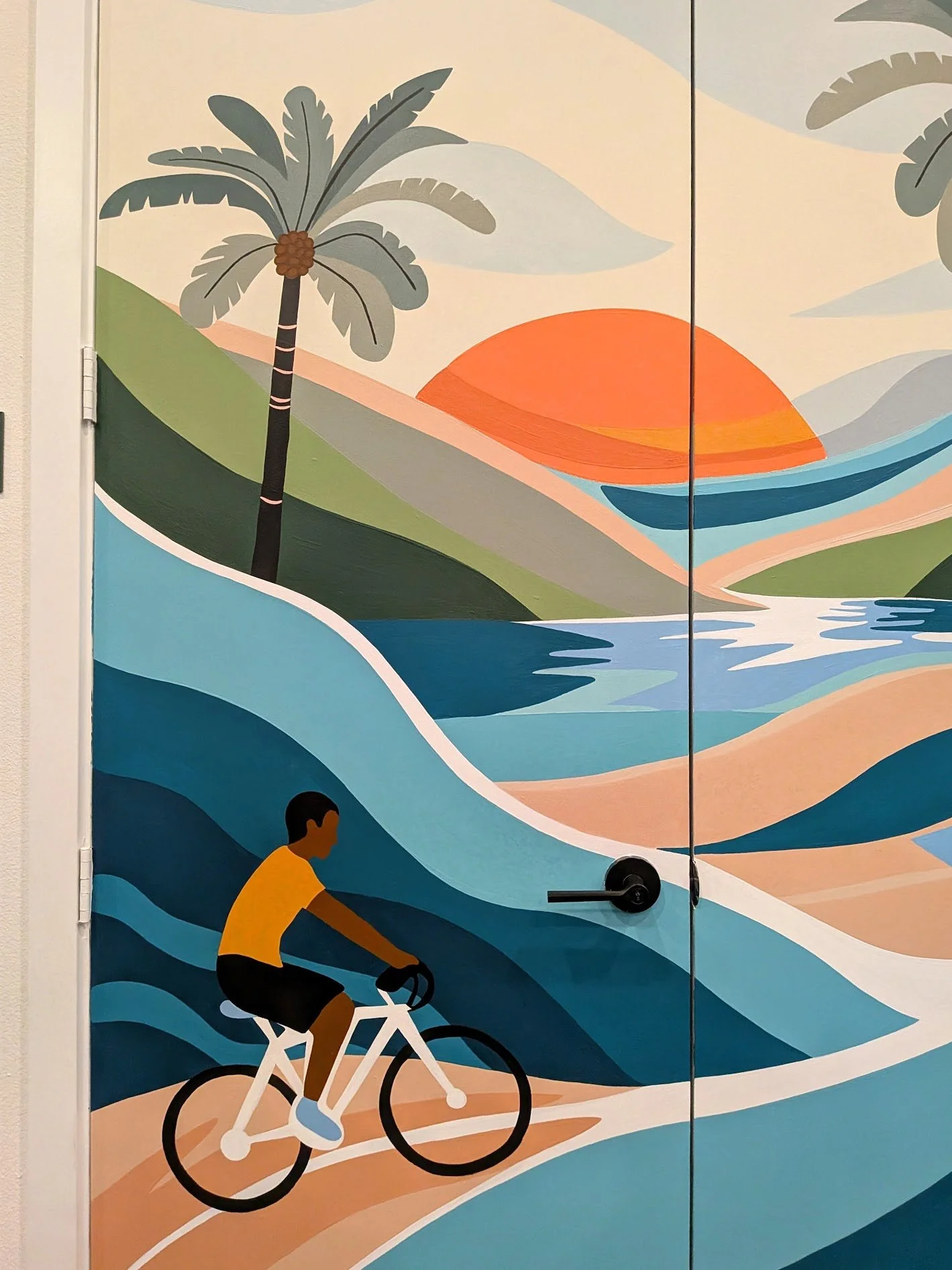 San Antonio apartment community fitness center mural featuring a cyclist, palm trees, sunset, and colorful abstract waves.