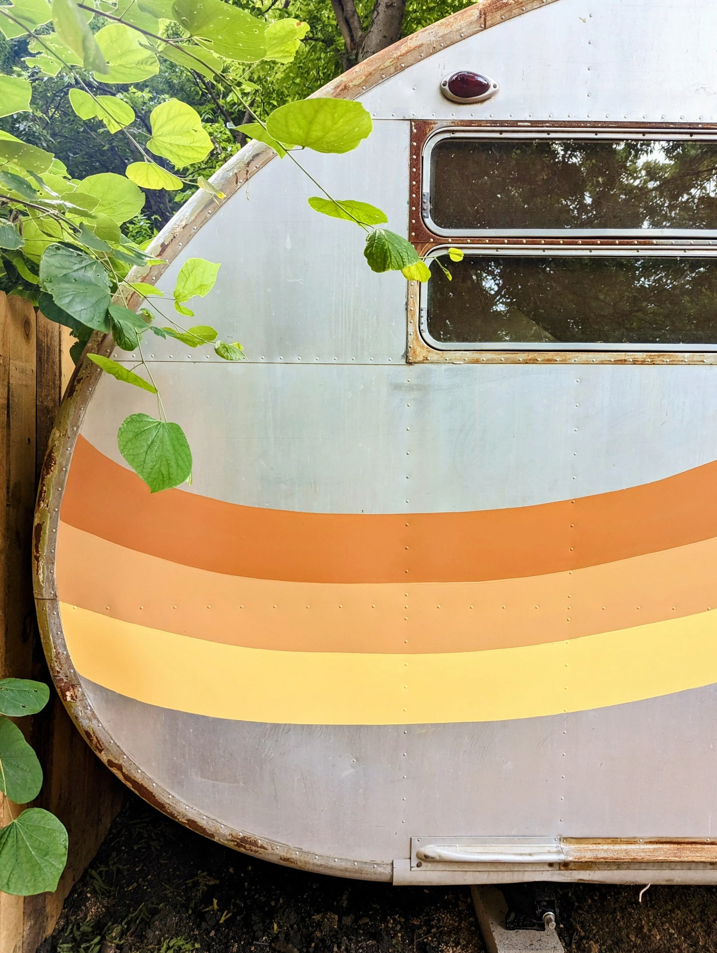 The Howdy Hideaway Austin Airbnb featuring a retro orange wave mural on Spartan trailers.