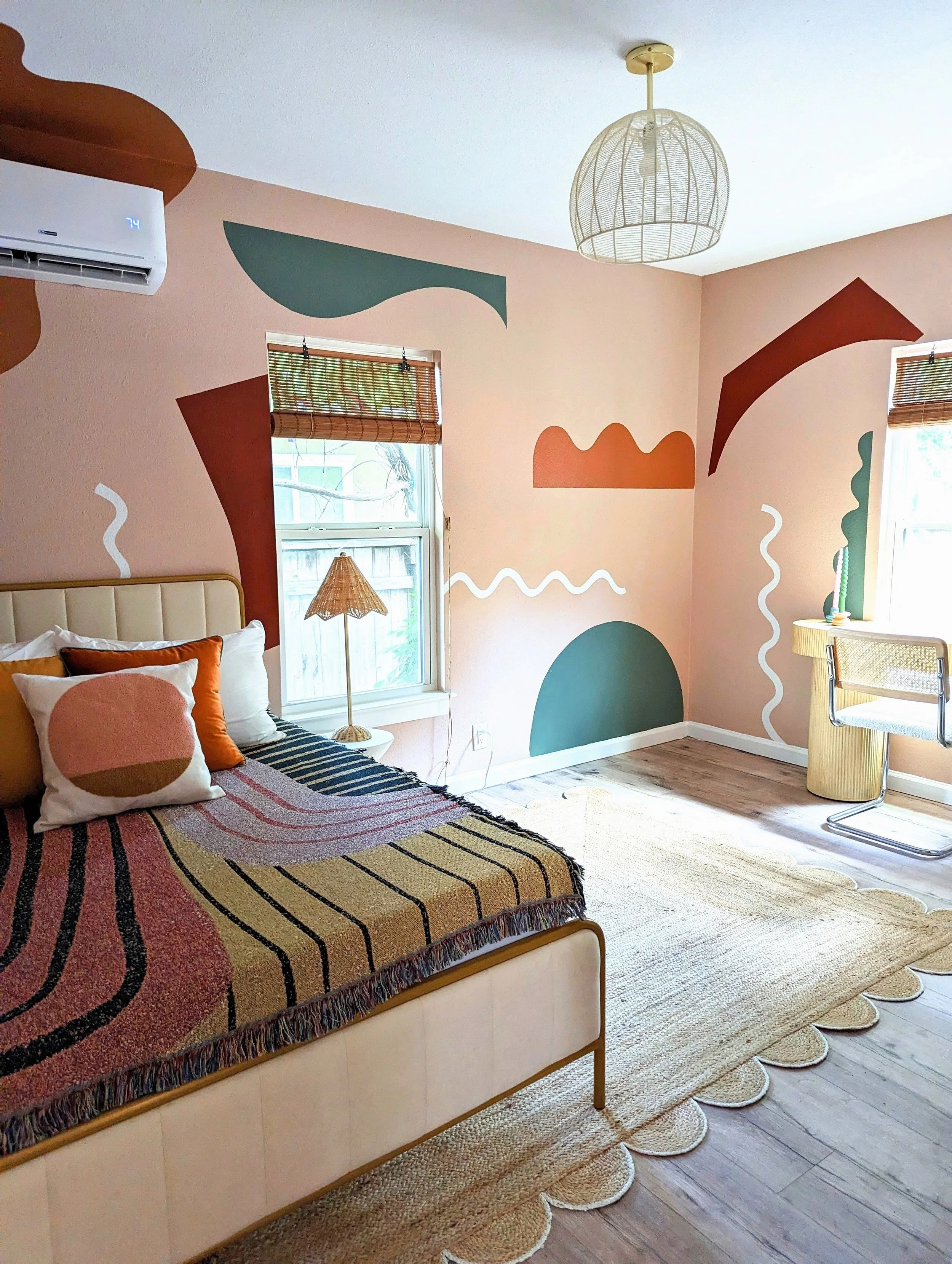 Austin Airbnb bedroom featuring an organic mural, vintage decor, eclectic finds, and layered earthy tones by Tola Home.