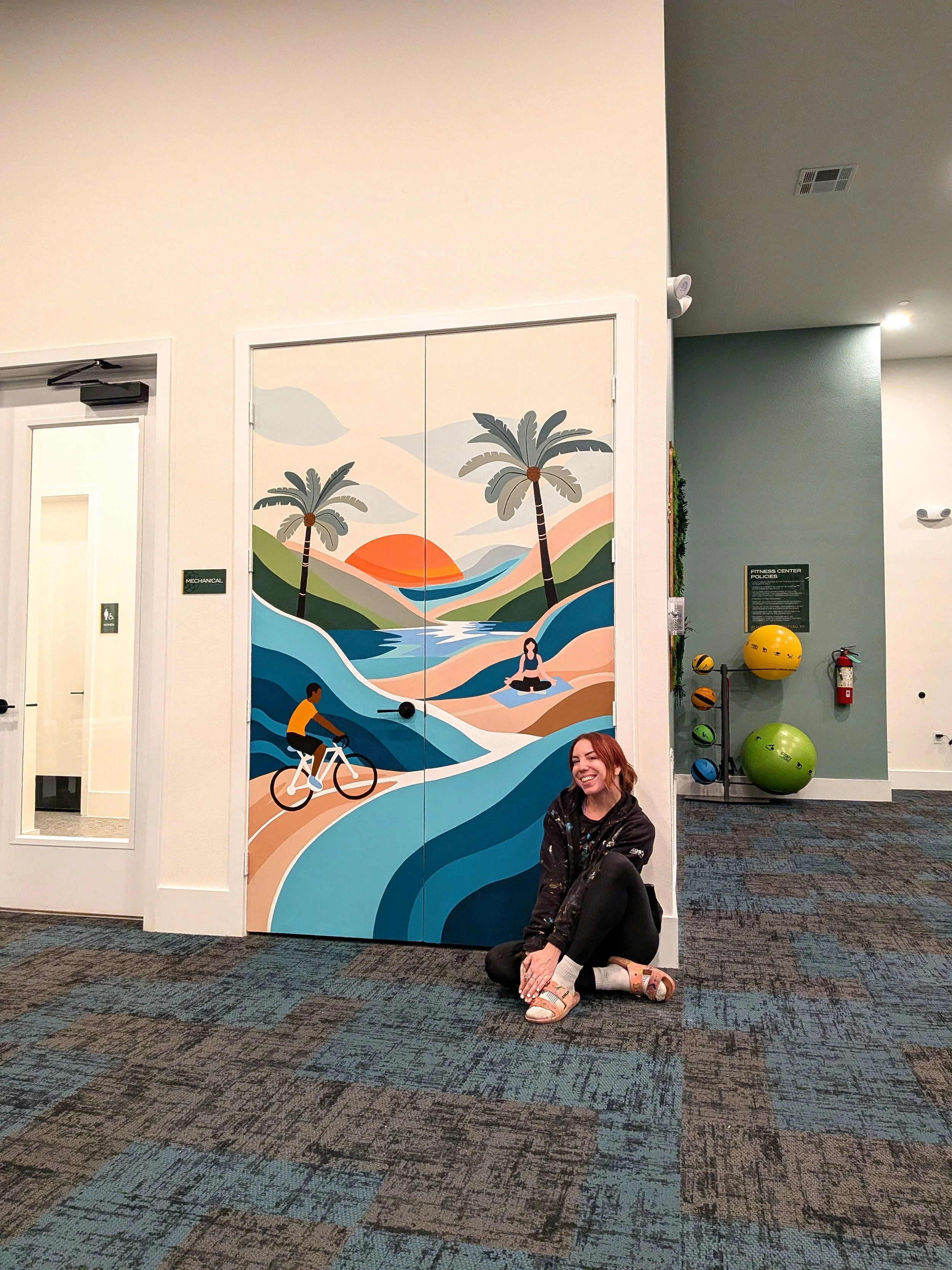 San Antonio apartment community fitness center mural featuring a tropical landscape, cyclist, yoga figure, and palm trees.