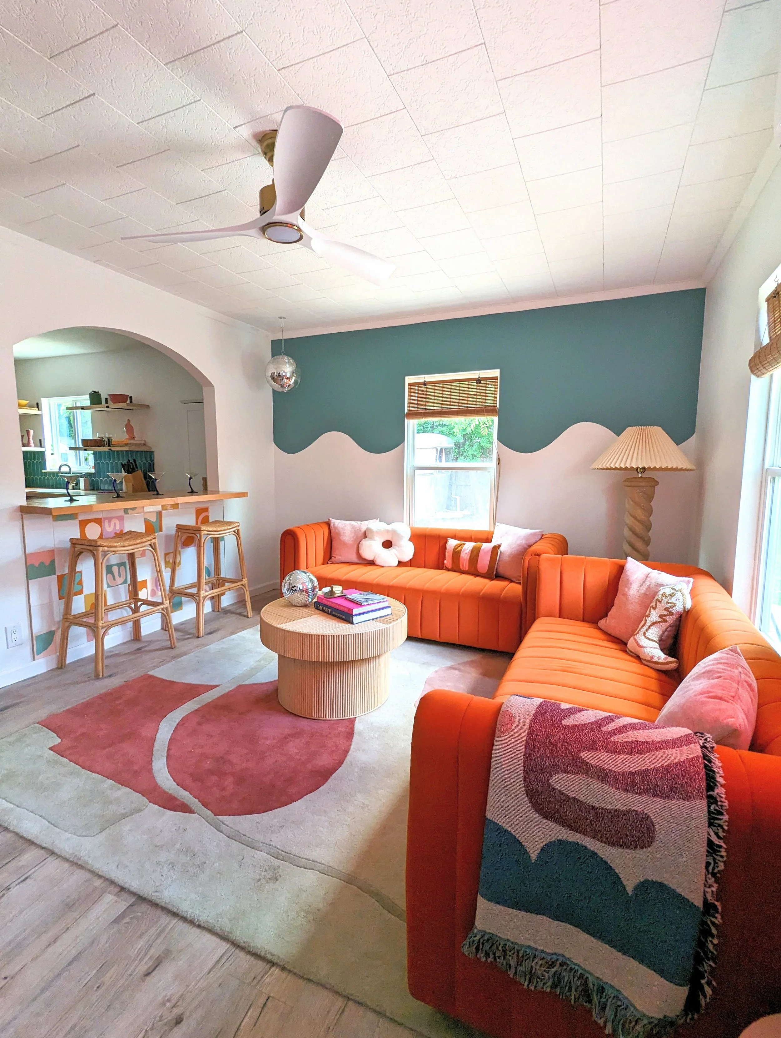 Austin Airbnb interior featuring a colorful mural, vintage furniture, eclectic decor, and collected vintage finds by Tola Home.