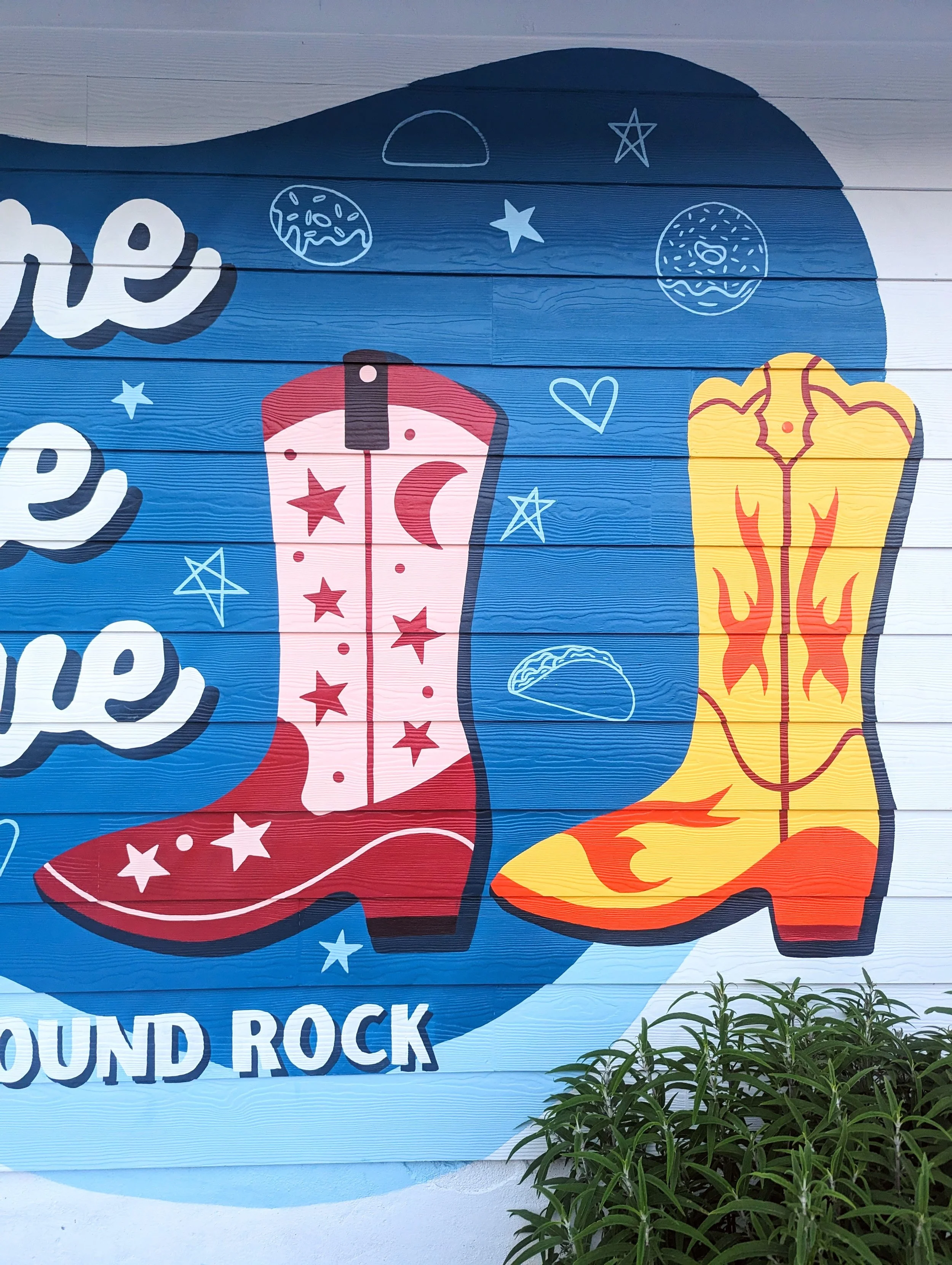 Round Rock, Texas short-term rental mural featuring a painted cowboy boot, wildflowers, and colorful Texas-inspired artwork.
