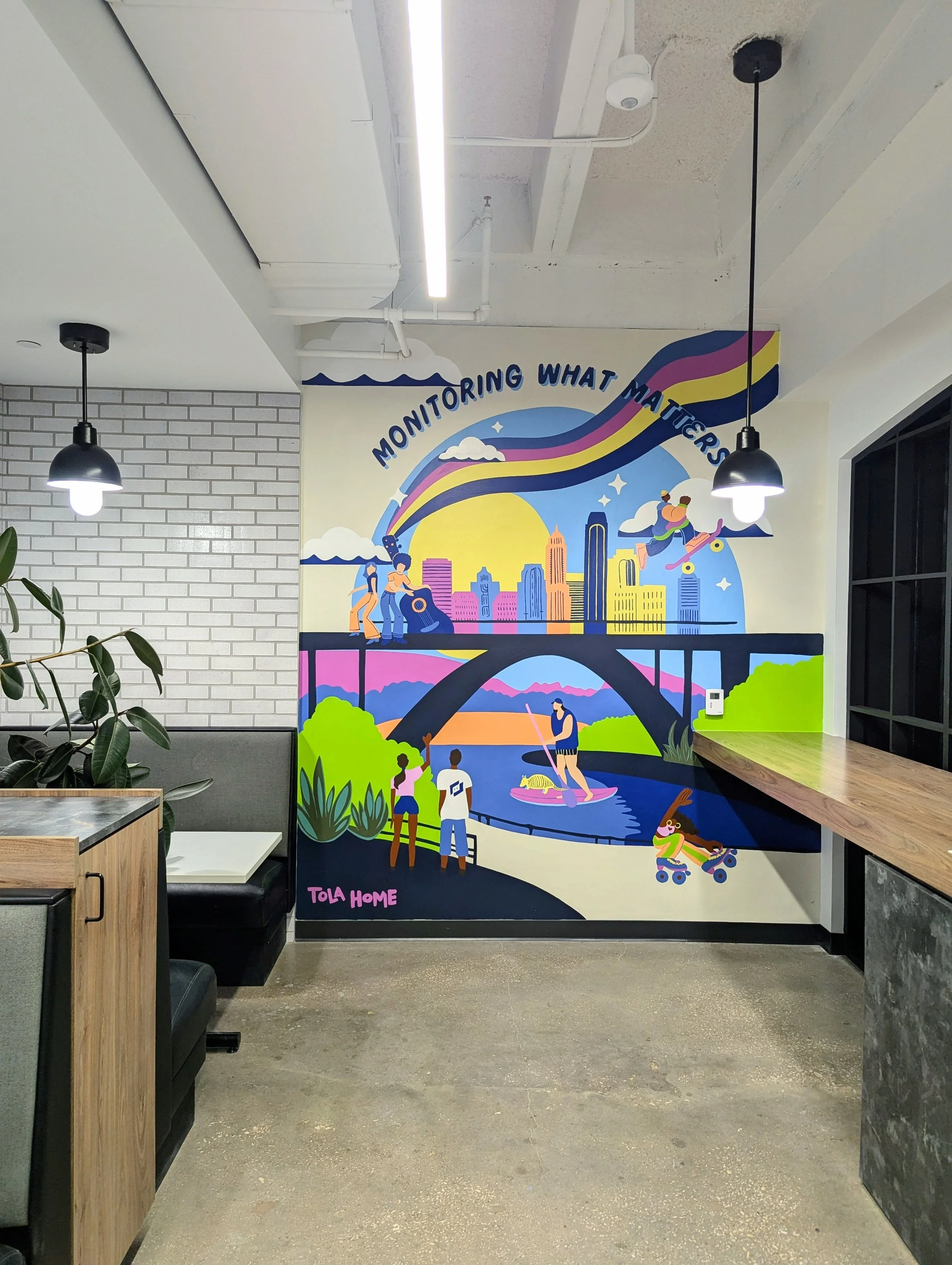 LogicMonitor office mural in downtown Austin featuring the company's brand colors, Austin-inspired artwork, and the “Monitoring What Matters” message.