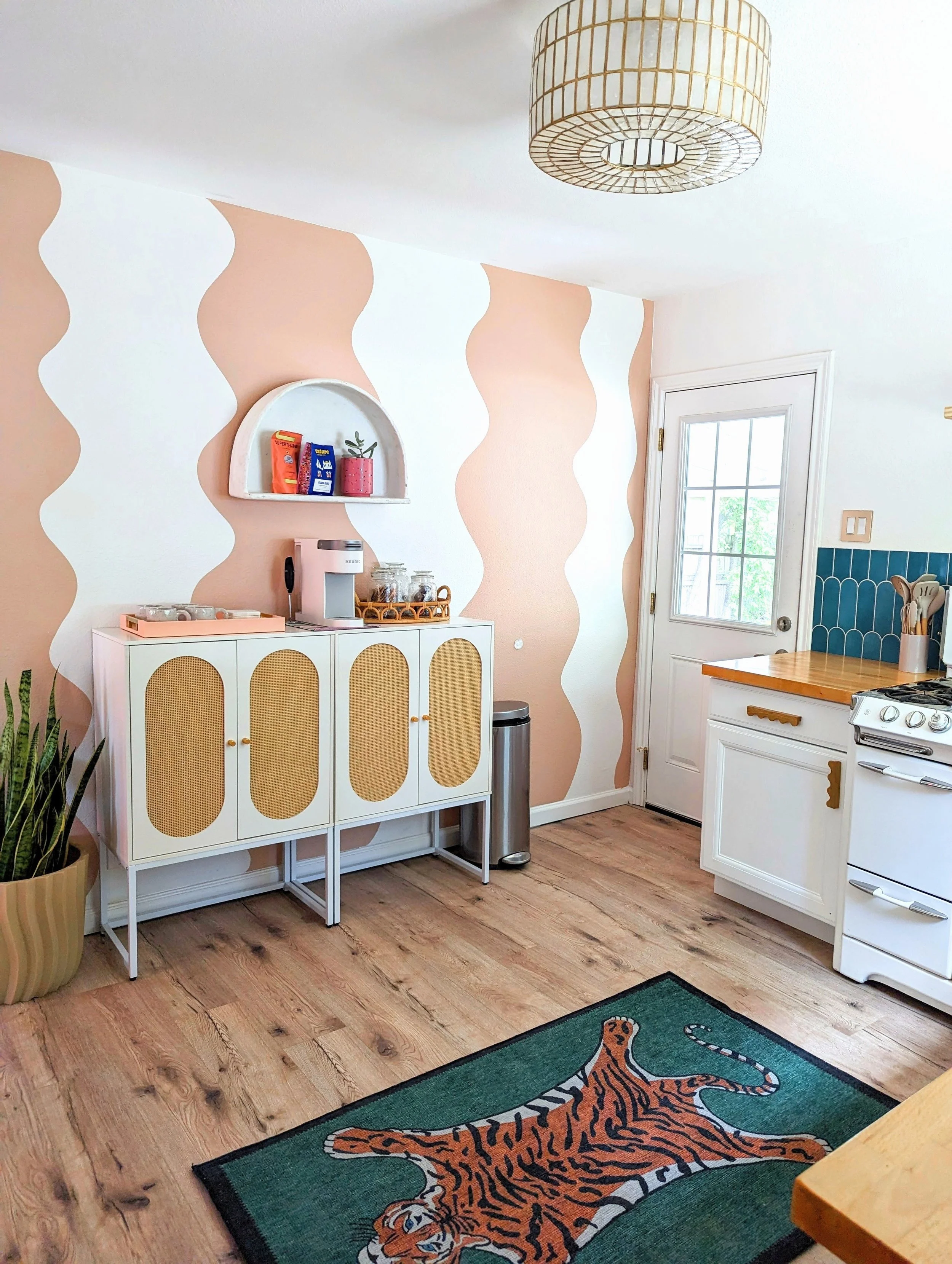 Austin Airbnb dining room featuring a squiggly earthy pink mural, vintage furnishings, and eclectic decor by Tola Home.