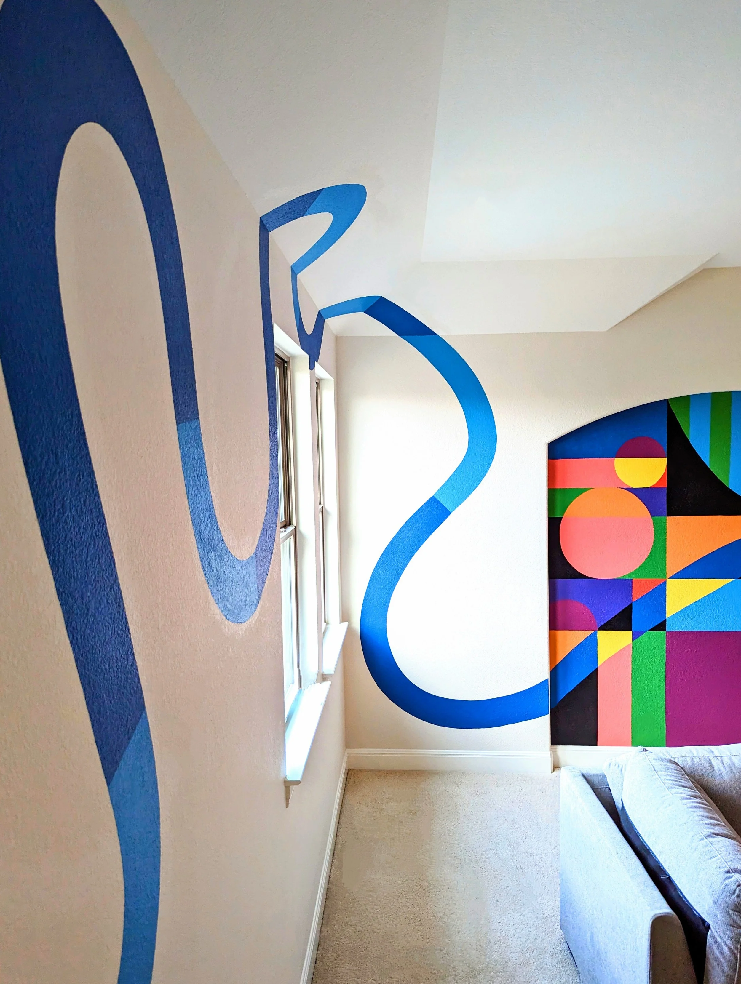 Leander, Texas playroom mural featuring a bold blue wavy curved design alongside colorful geometric wall art.