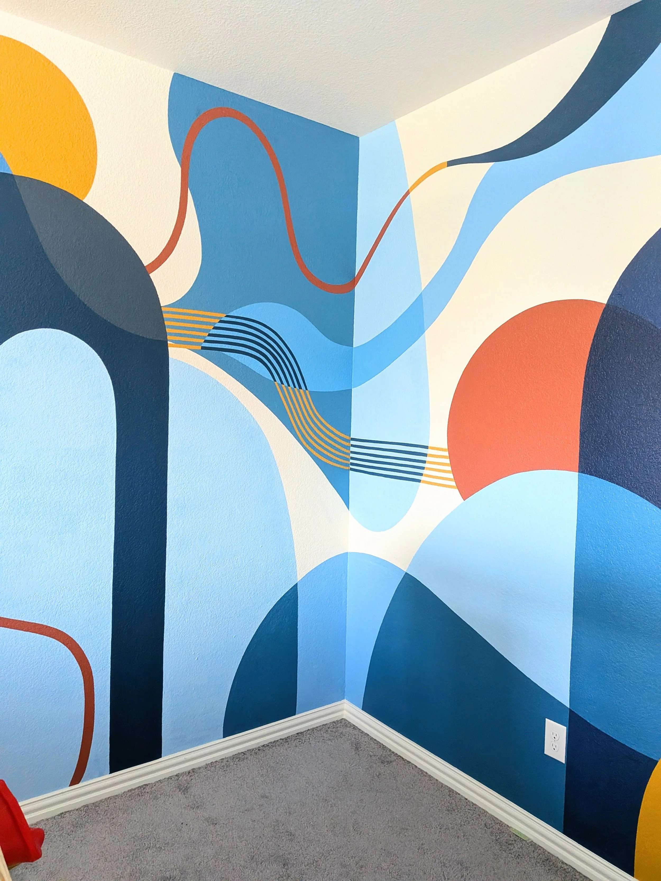 Buda, Texas family playroom mural wrapping around the room with colorful abstract shapes and playful geometric artwork.