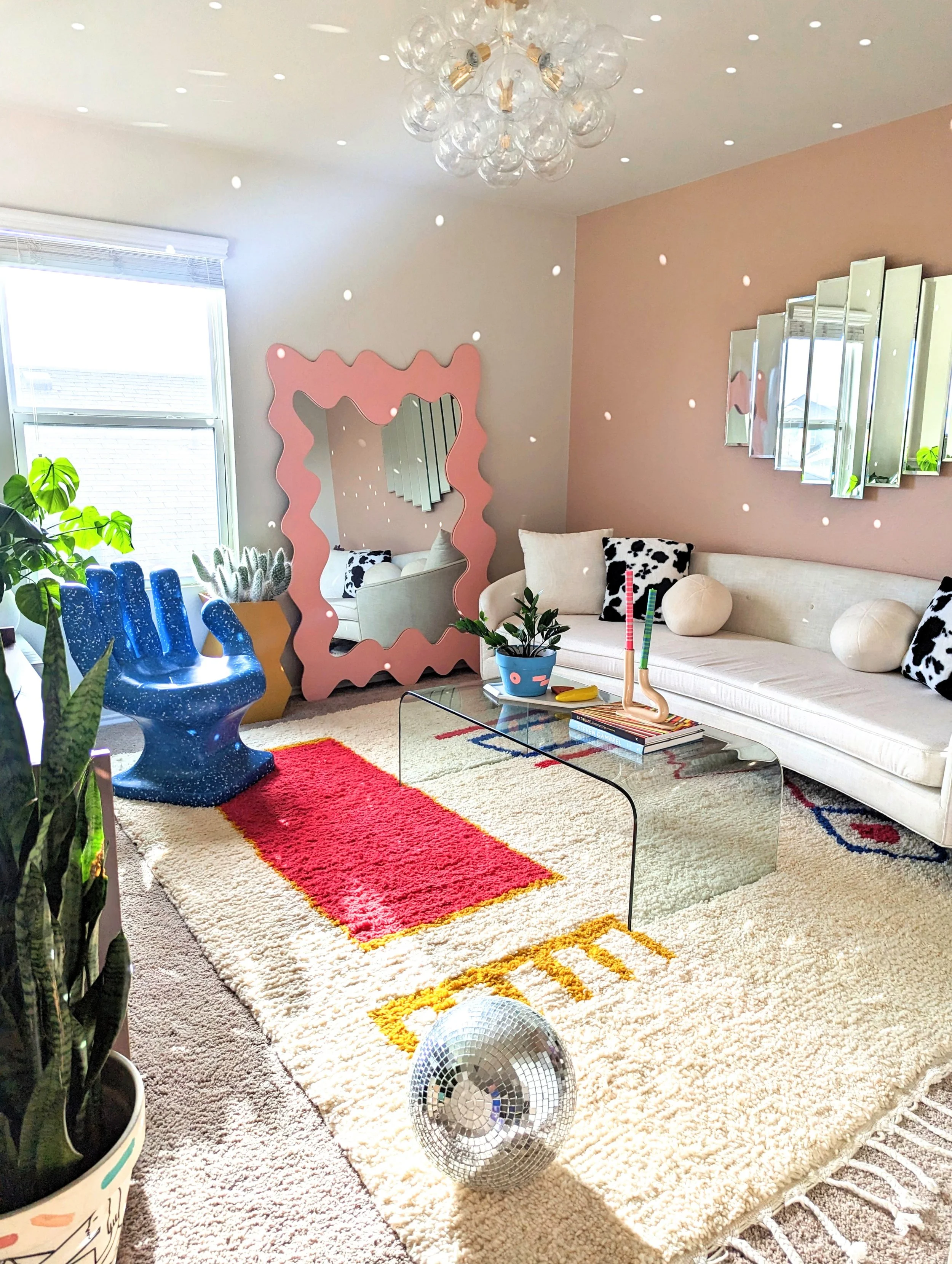 A Colorful living room in an Austin-area home featuring original artwork, eclectic decor, vintage finds, and playful details, featured in Apartment Therapy.