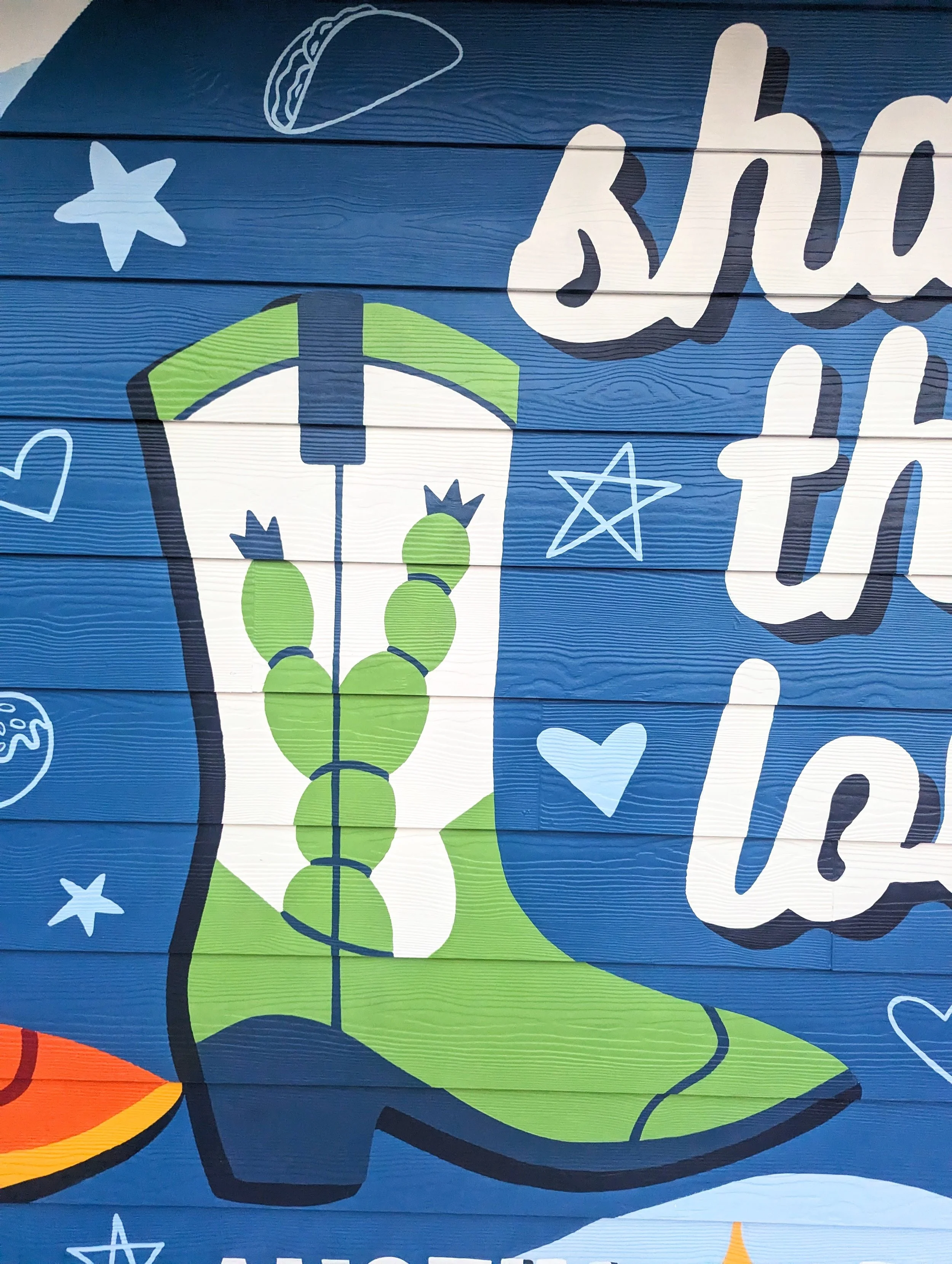 Round Rock, Texas short-term rental mural featuring the "Share the Love" message, cowboy boots, flowers, and Texas-inspired details.