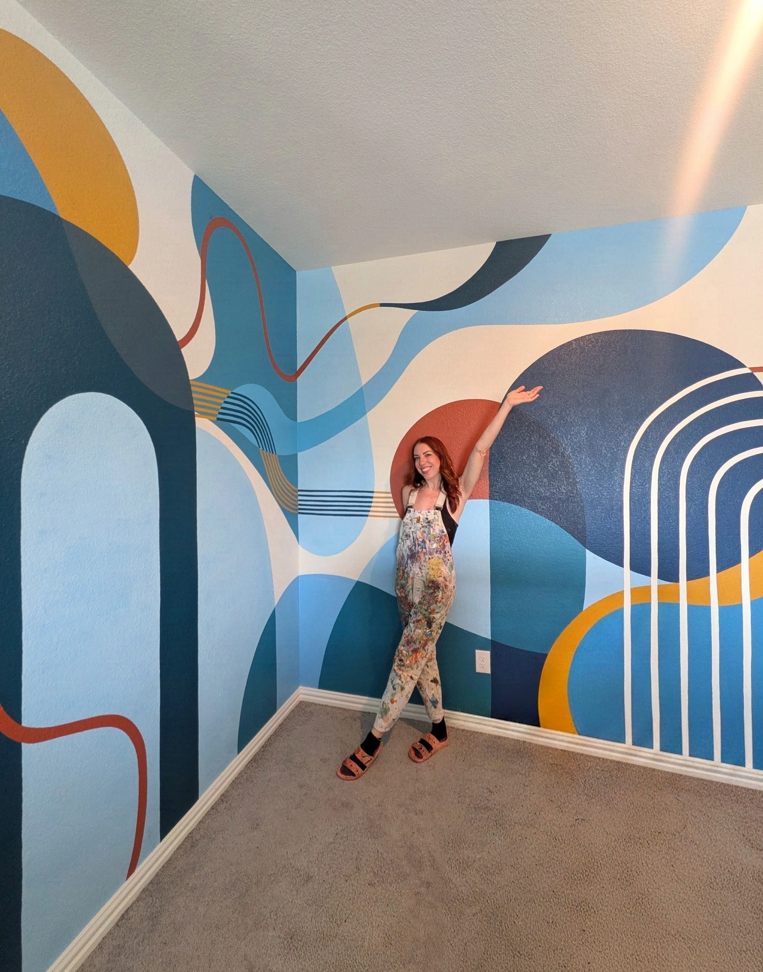 Buda, Texas playroom mural featuring colorful abstract arches and geometric shapes painted across two adjoining walls.