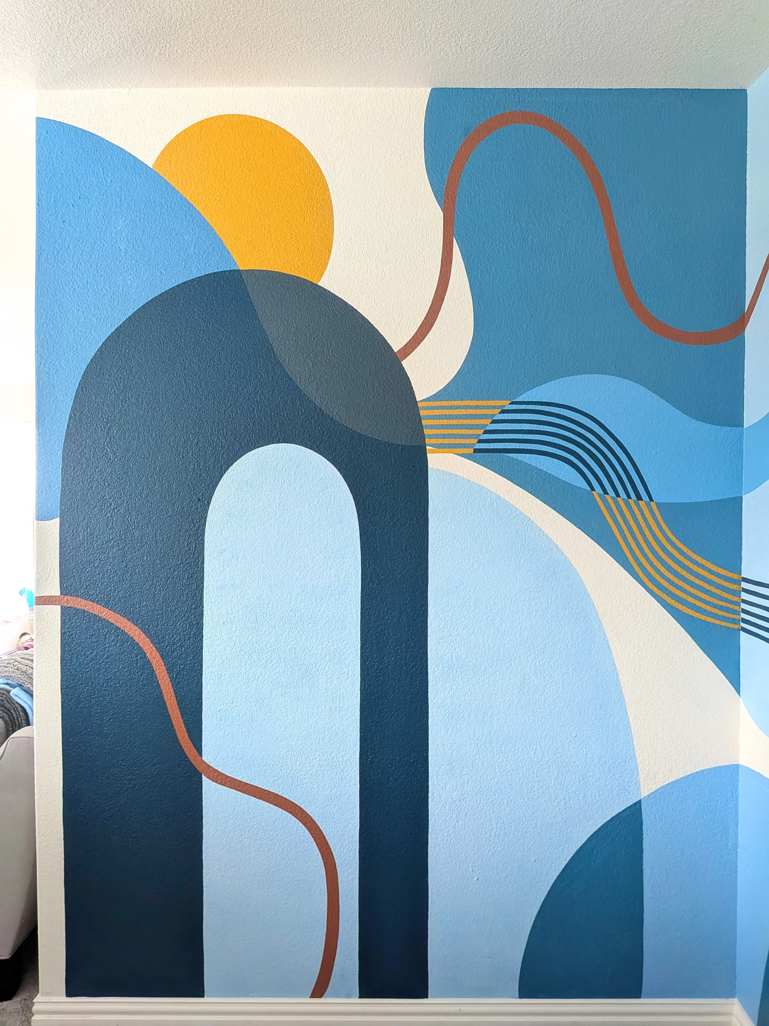 Buda, Texas family playroom with a bold geometric mural spanning two walls and creating a continuous colorful design.