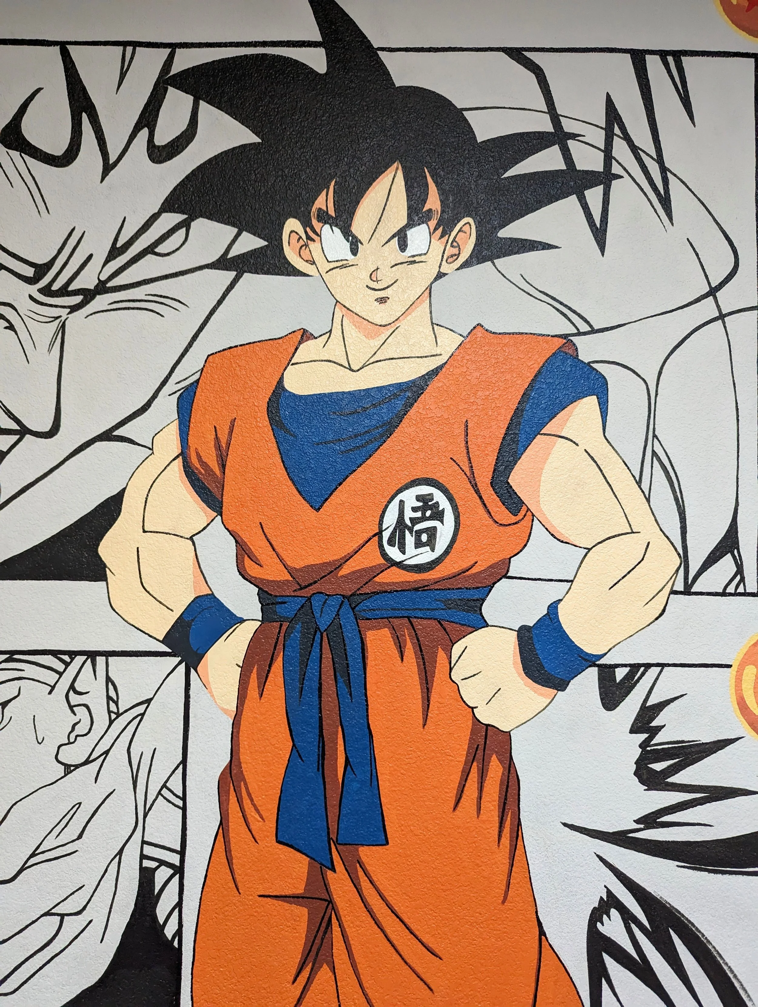 Colorful Goku mural in an Austin office featuring black-and-white Dragon Ball Z manga panels across the background.