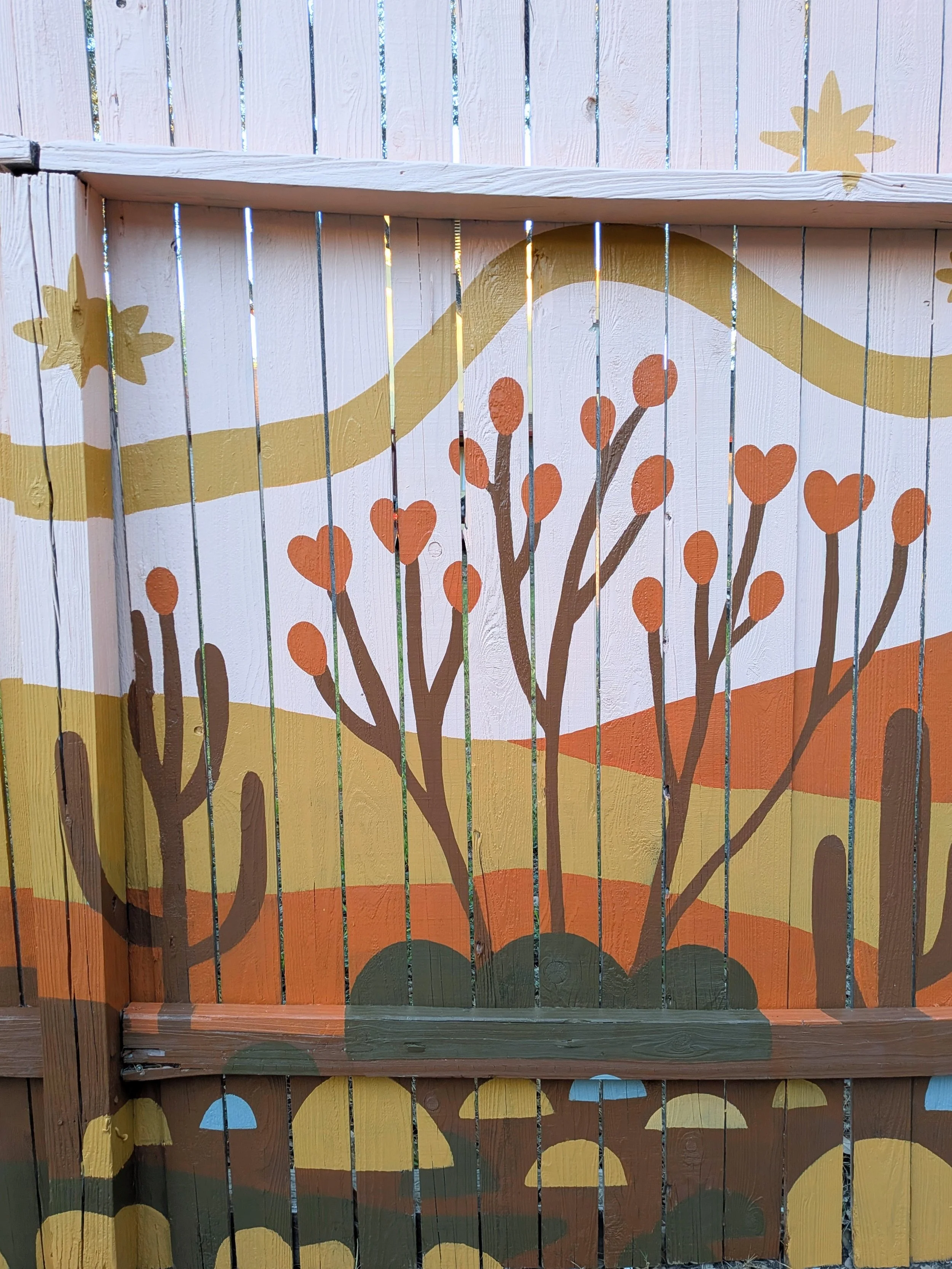 Arroyo House exterior mural in San Antonio featuring property branding centered within a 60-foot painted desert landscape fence.