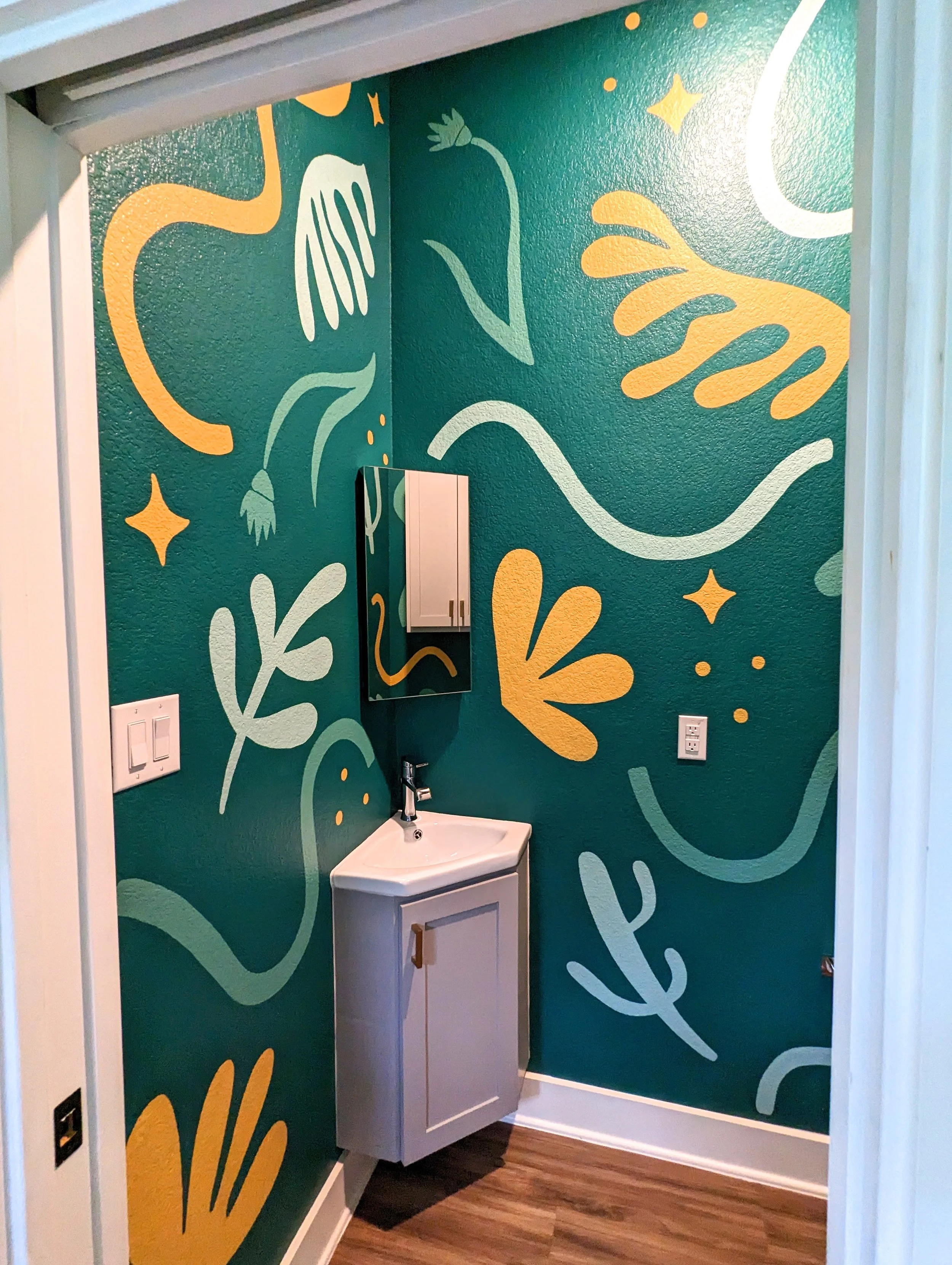 Austin small powder room bathroom featuring a color-drenched green mural with botanical details, organic shapes, and decorative sparkles.