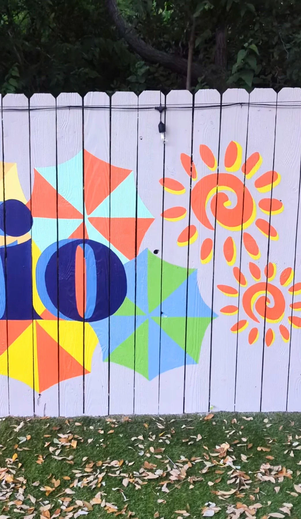 San Antonio fence mural featuring colorful fiesta umbrellas representing the city's River Walk and blue “SAN ANTONIO” lettering.