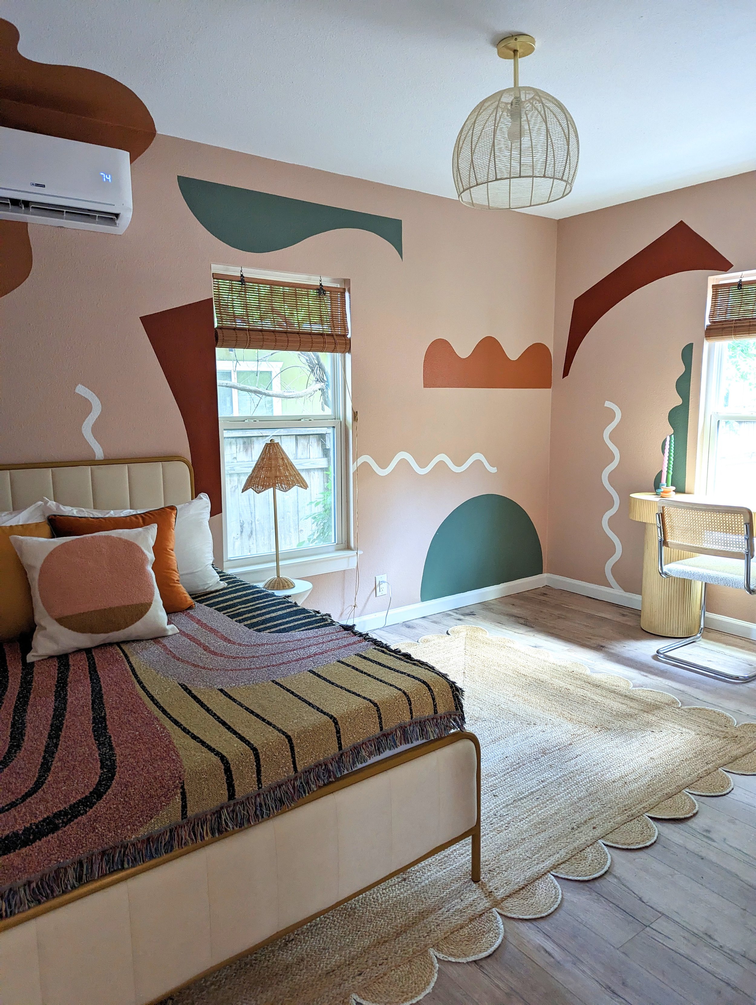 Austin Airbnb The Howdy Hideaway bedroom featuring an earthy-toned organic mural, vintage furnishings, and eclectic decor by Tola Home.