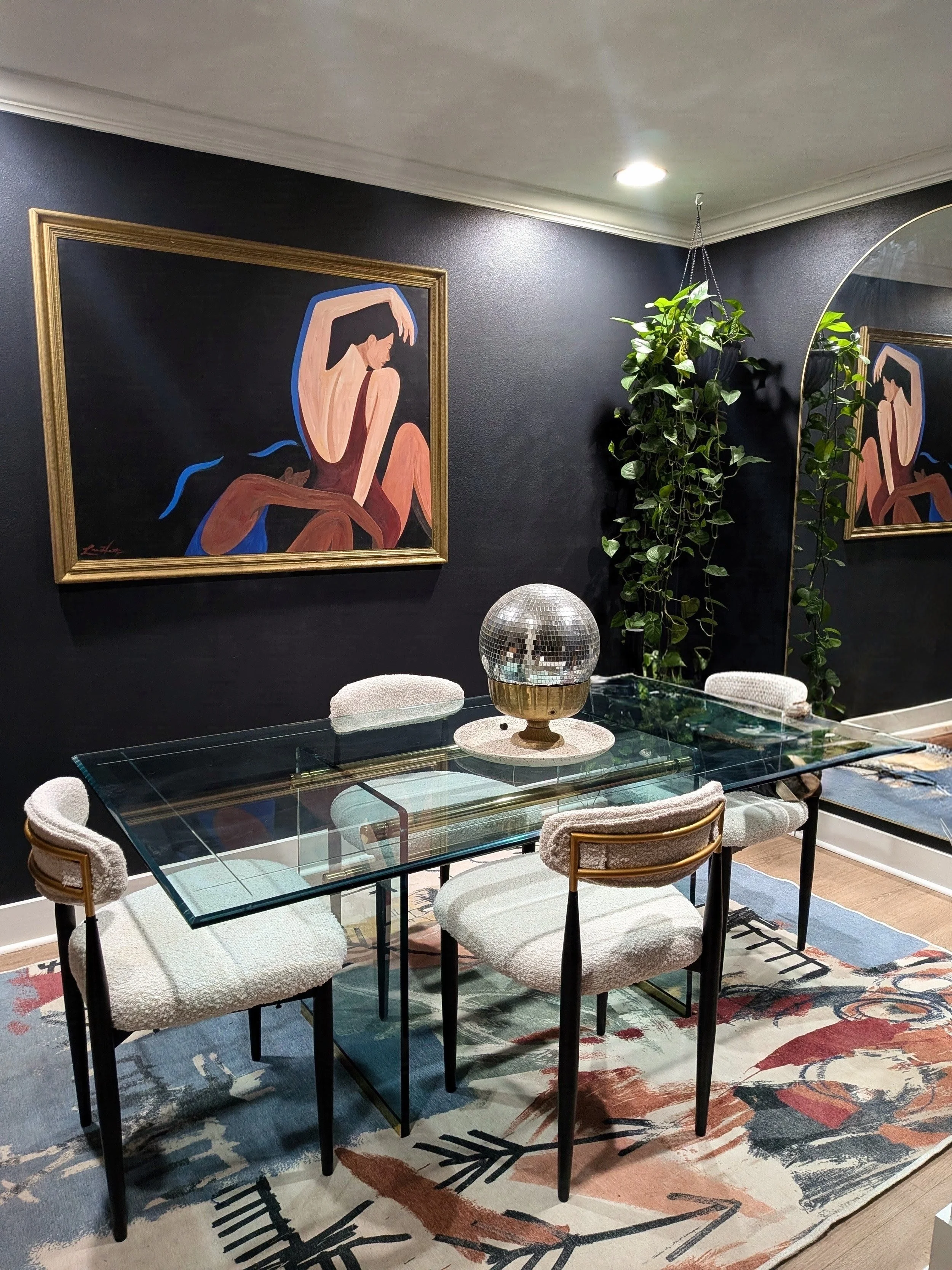 Dining room in Laura's Austin home featuring original Tola Home artwork, eclectic decor, and a moody interior.