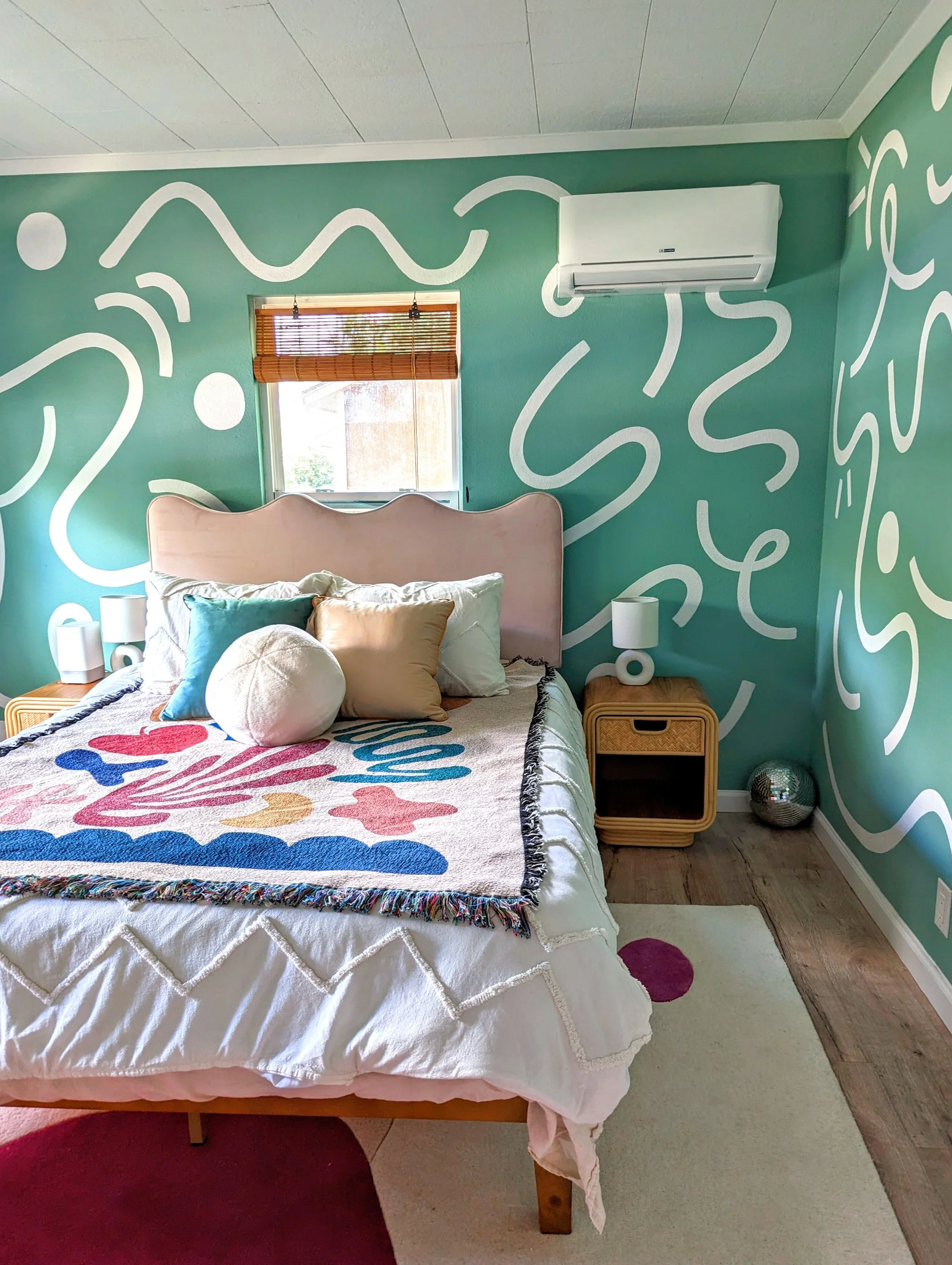 Austin Airbnb bedroom featuring a green abstract mural, vintage furnishings, eclectic decor, and original artwork by Tola Home.