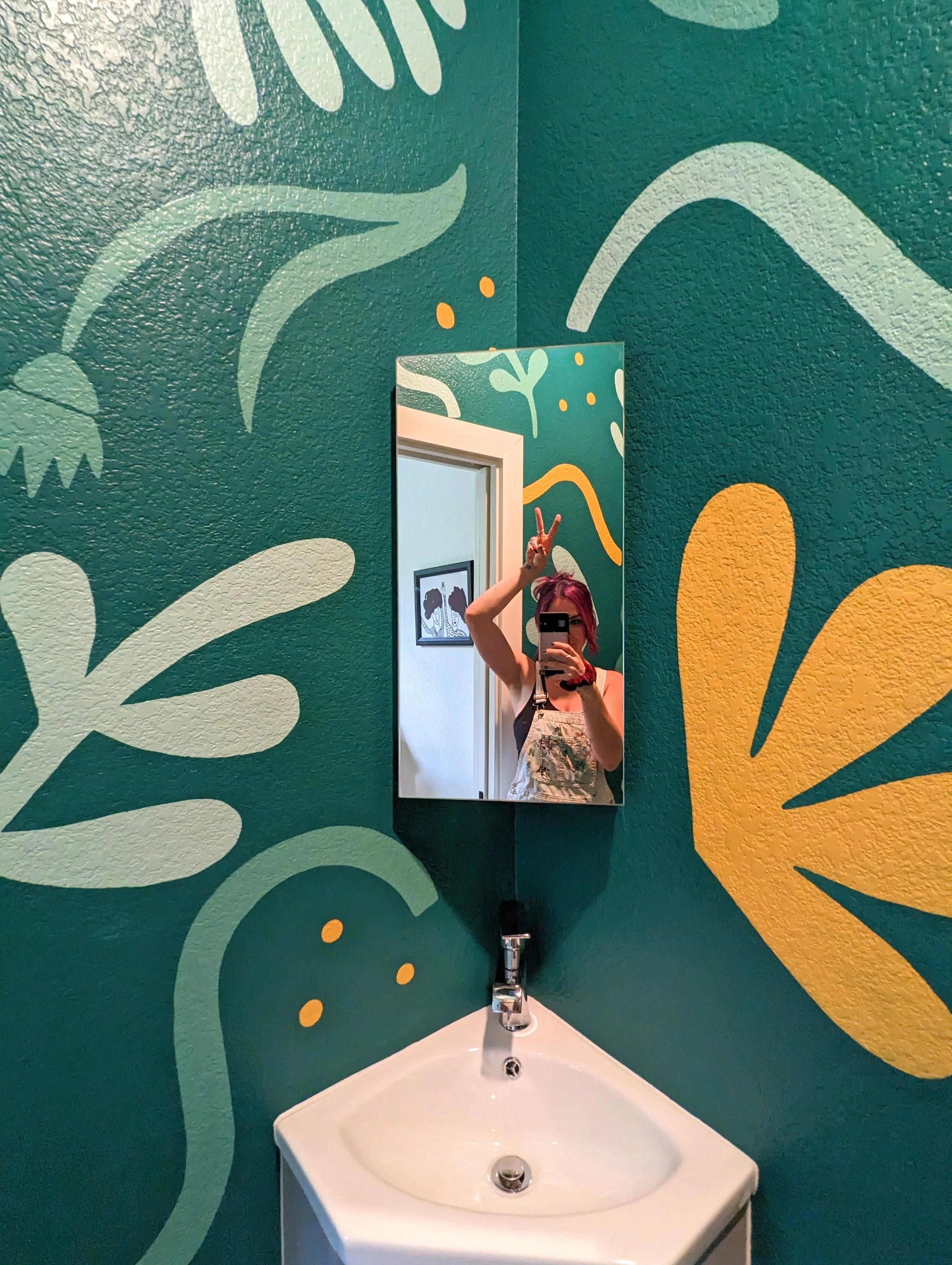 Emerald green bathroom mural in Austin featuring playful flowers, abstract shapes, and hand-painted details across the walls.